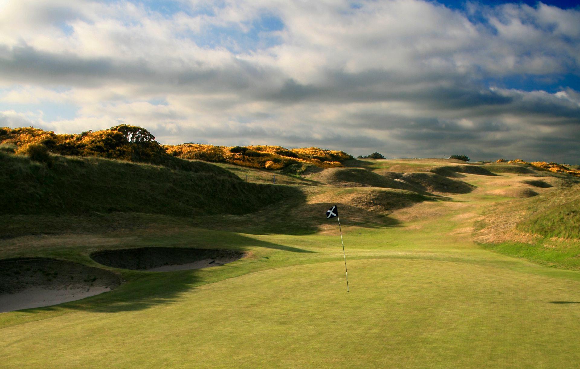 Overlooking the green at the course with Scottish sign on the flagstick