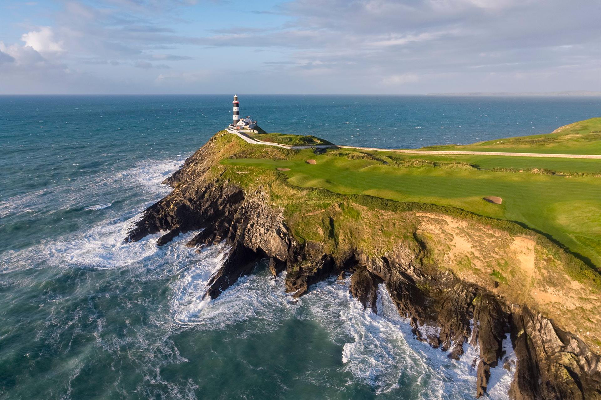 Waves crashing against cliffs beneath a coastal fairway.