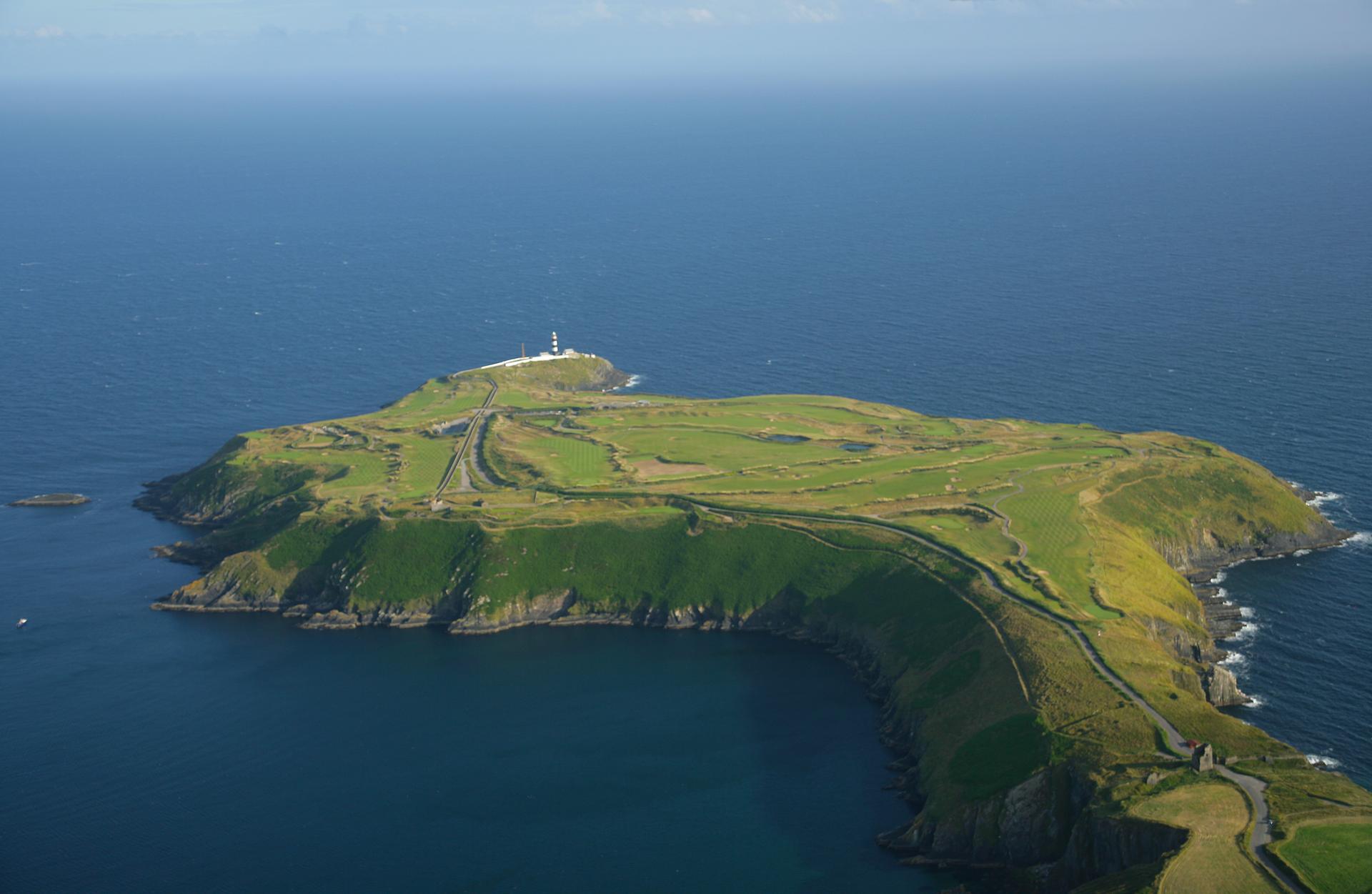 Aerial view of a peninsula golf course surrounded by sea.