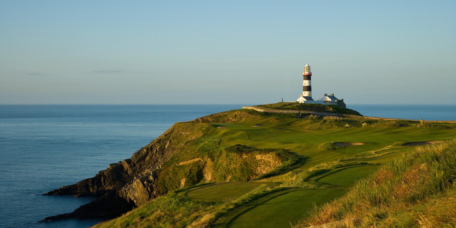 A lighthouse overlooking rugged cliffs and greens.