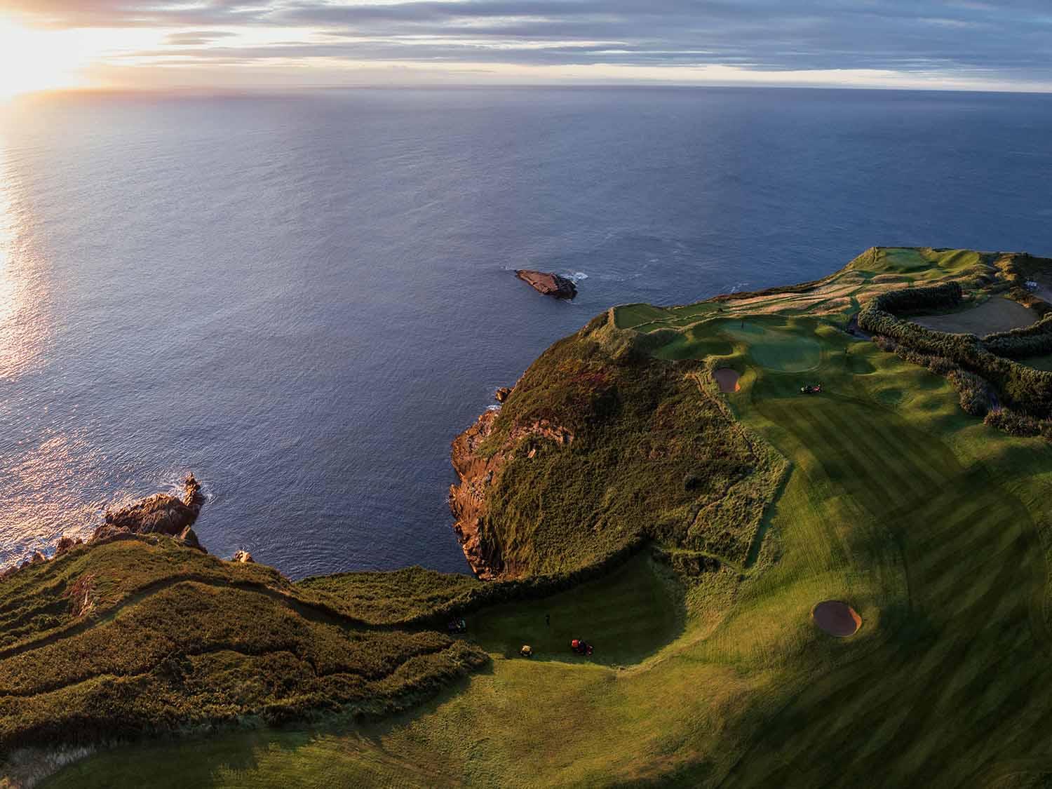 A stunning cliffside golf course with the ocean at sunset.