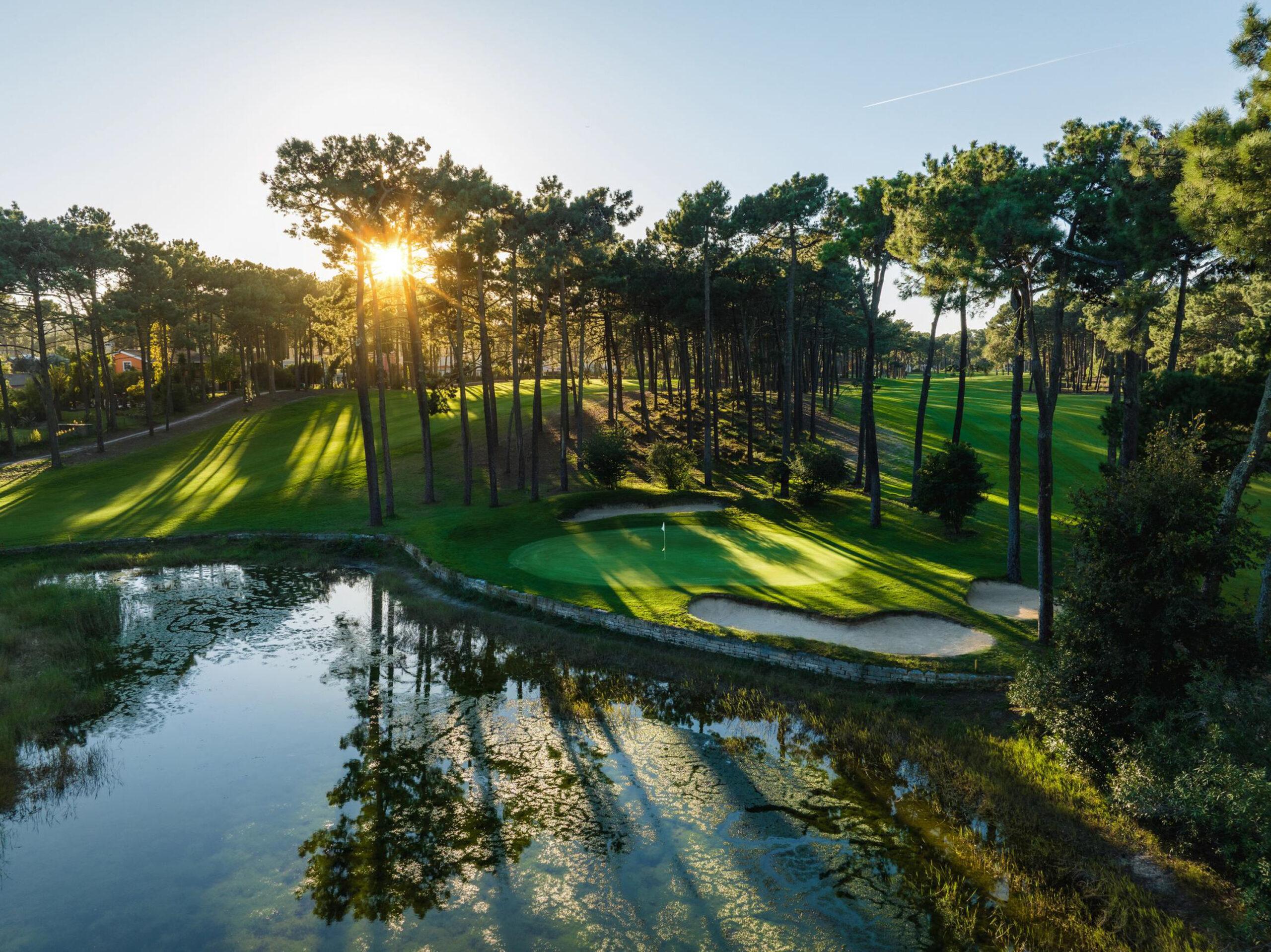Tee shot over water to a green with bunkers and trees around it