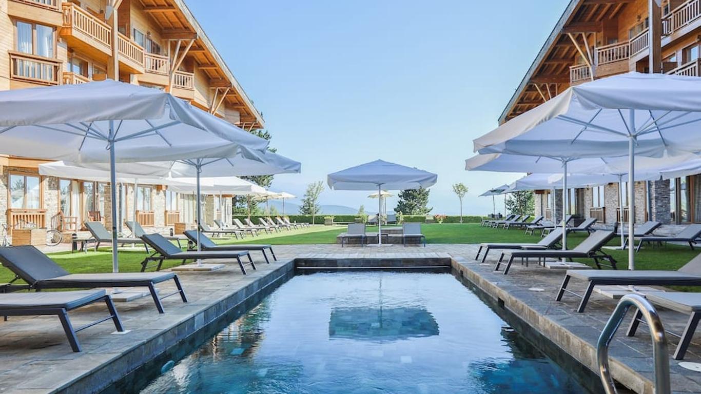 Outdoor swimming pool at the resort with surrounding sun beds and umbrellas