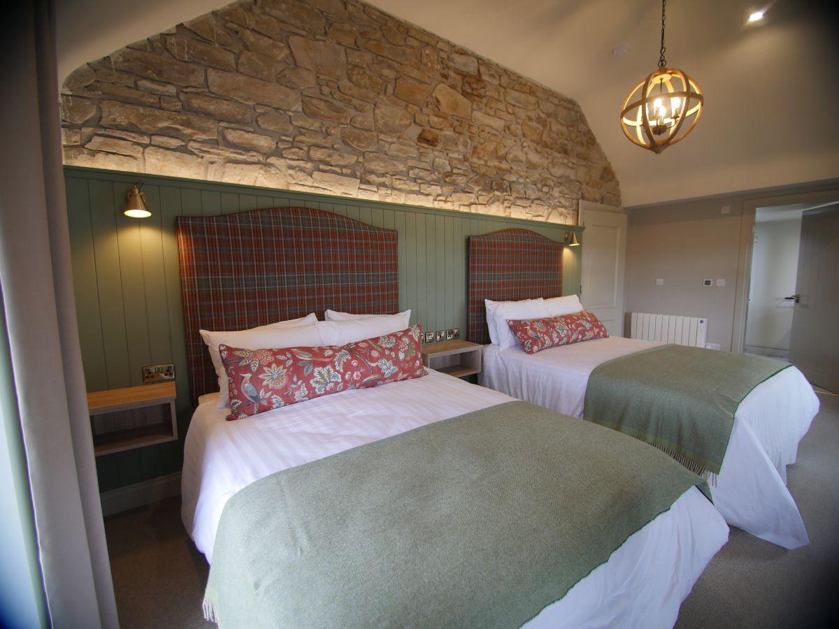Rustic double bed room at the Rosapenna Resort with a red and green colour theme