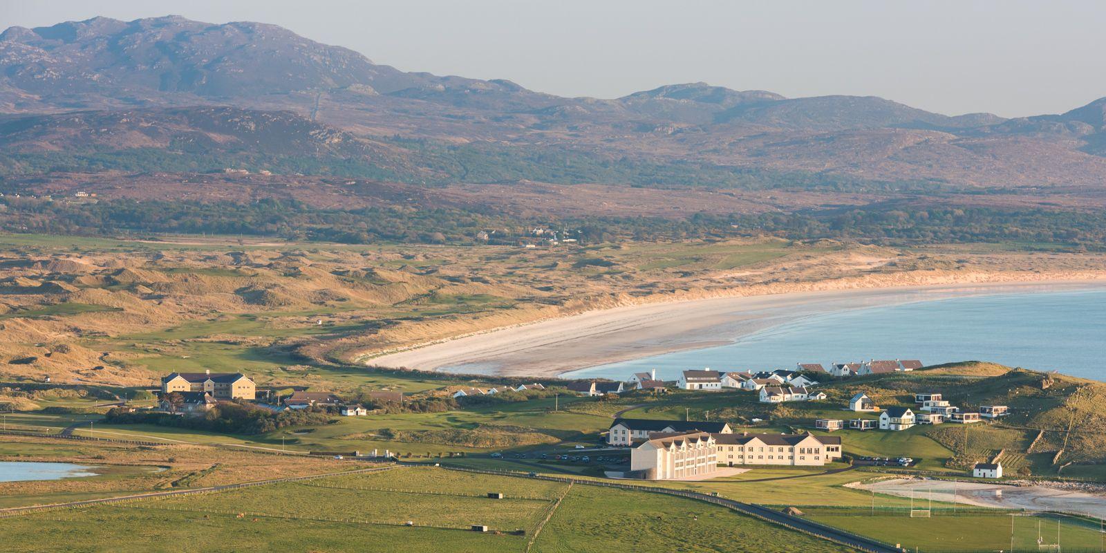 Aerial view of the resort, golf course, beach and mountains in the back