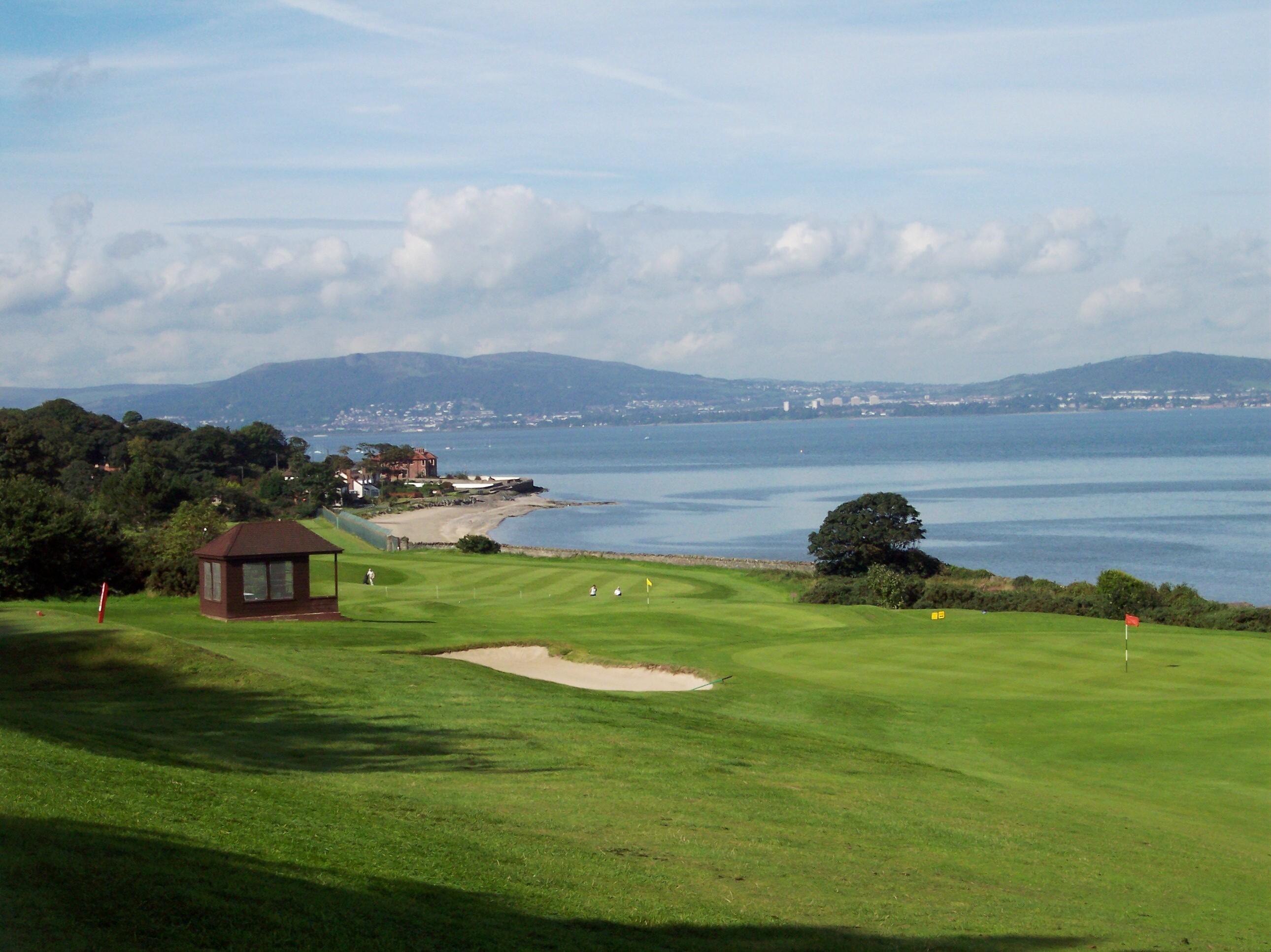 A coastal hole overlooking Belfast Lough with views of rolling hills and distant townships.