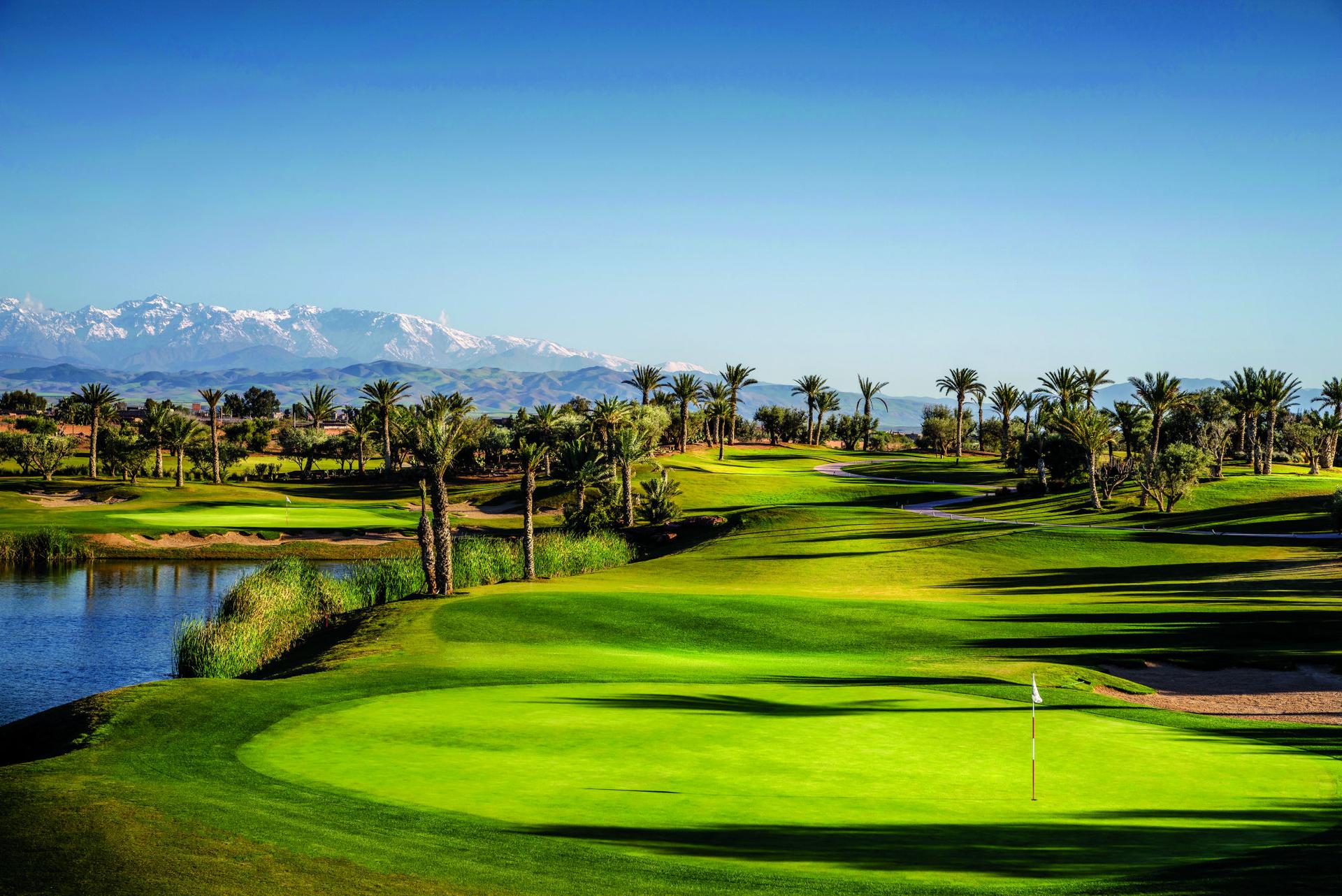 A well maintained straight fairway leading to a smooth green under blue skies