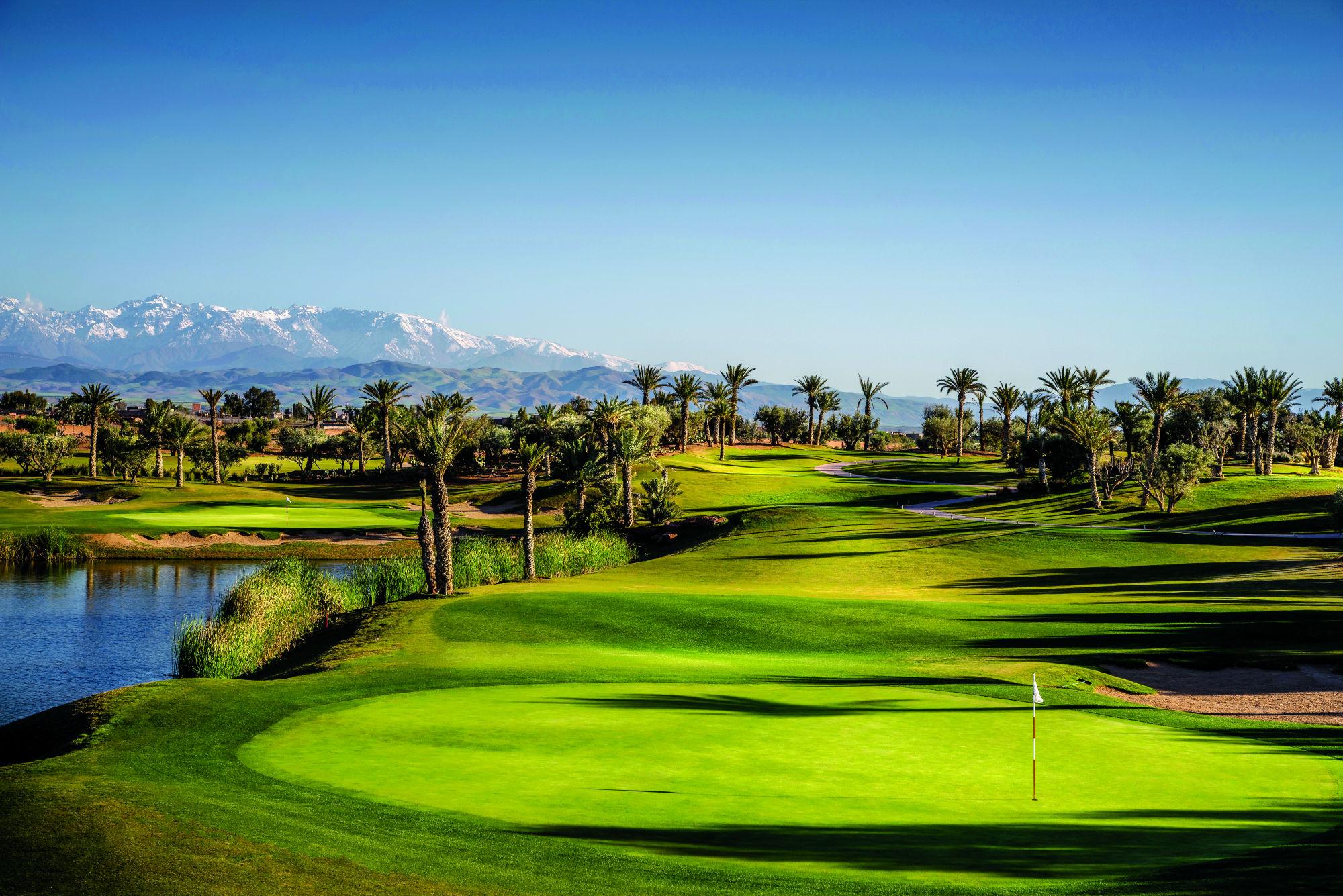 A well maintained straight fairway leading to a smooth green under blue skies