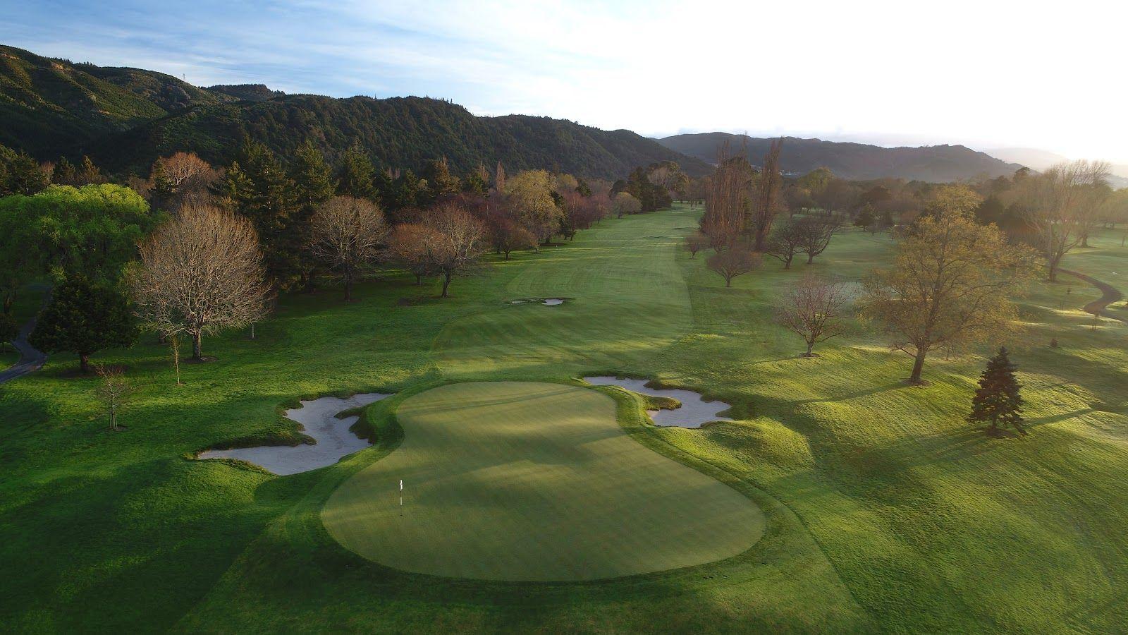 A wide fairway leading to a smooth green surrounded by sand bunkers