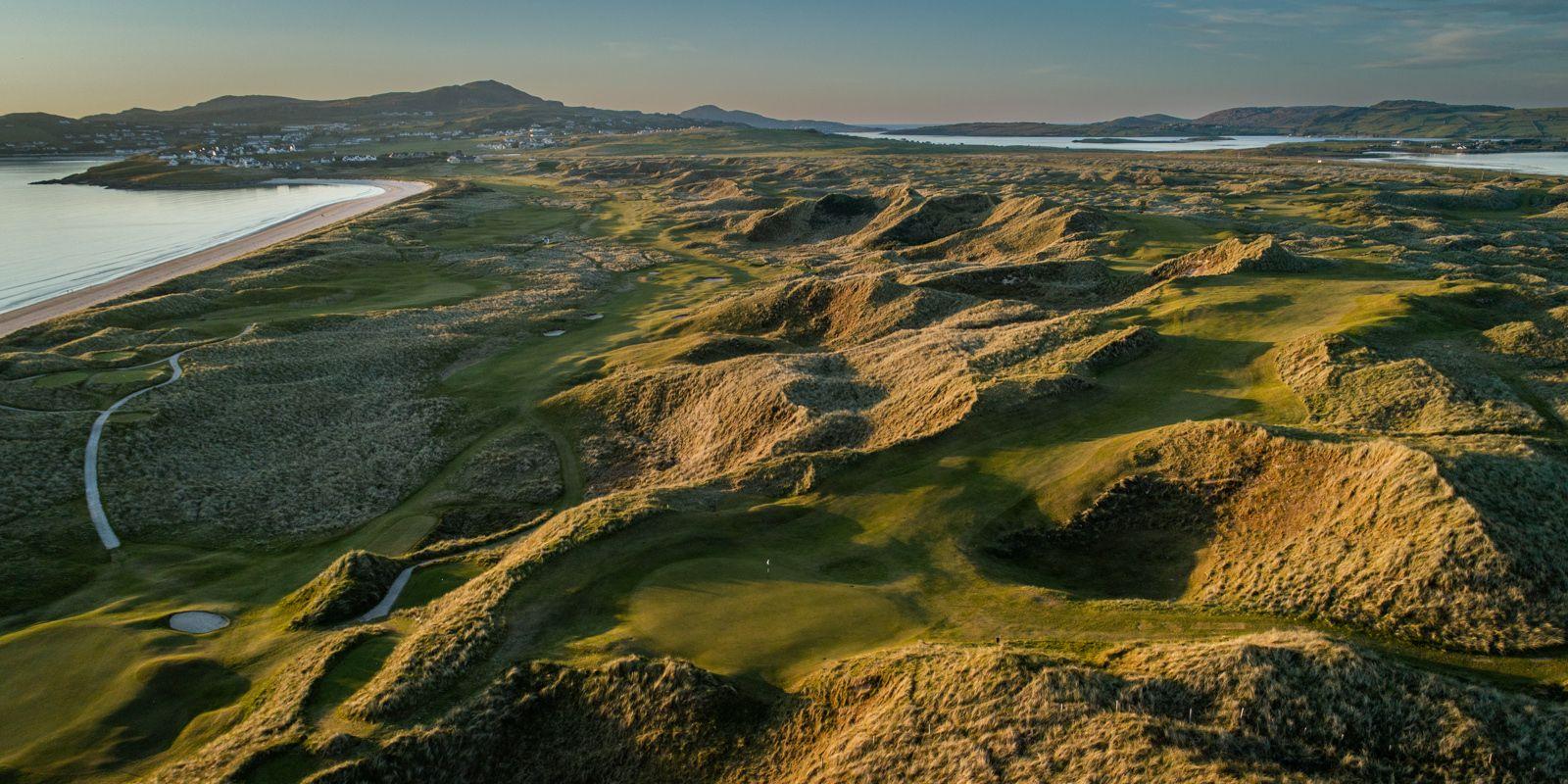 Birds-eyes view of the greens surrounded by a hilly landscape