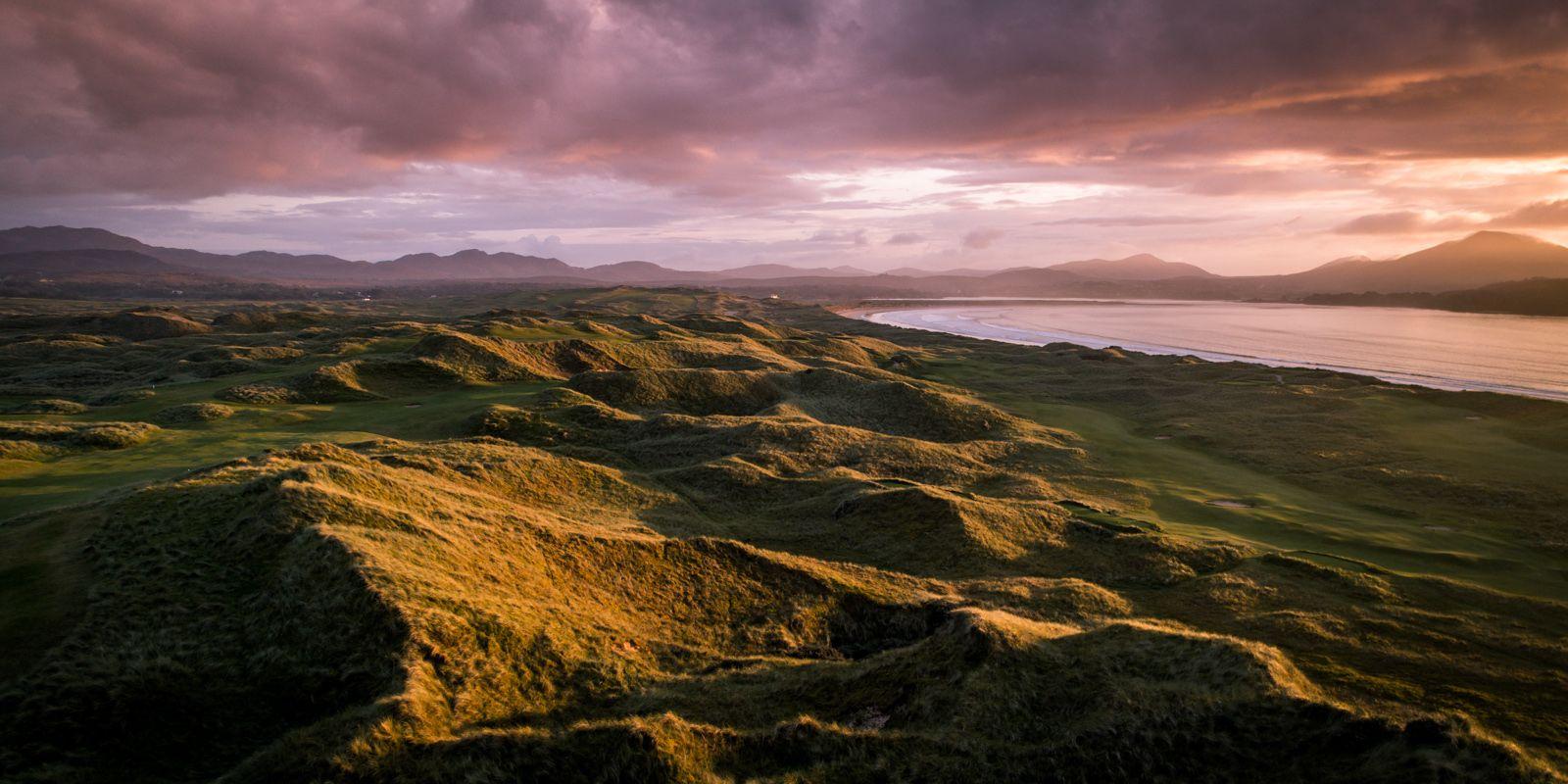 Mountainous landscape next to the firm fairways while the sun is setting