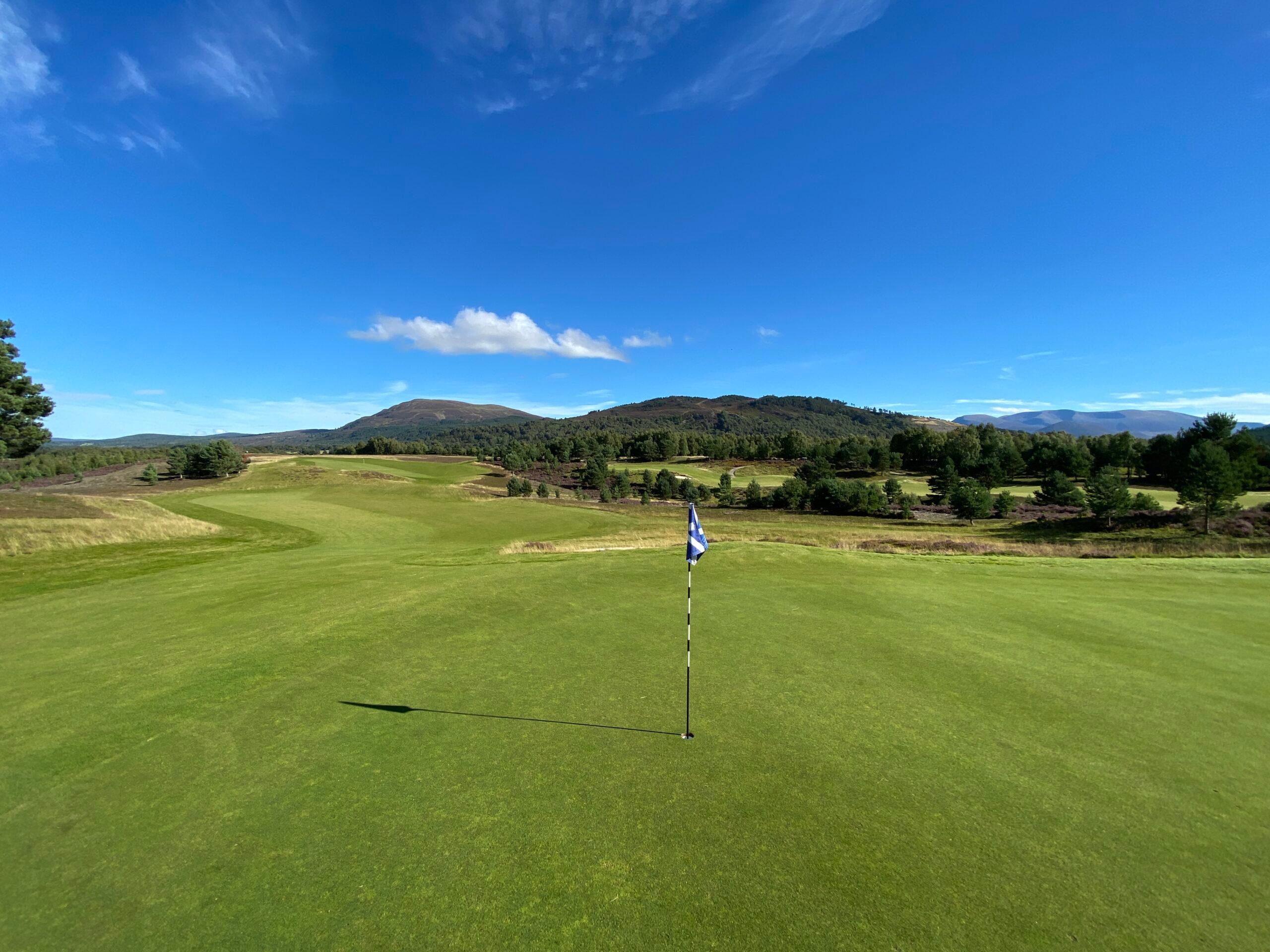 Firm fairways and flagstick representing the putting hole with blue skies