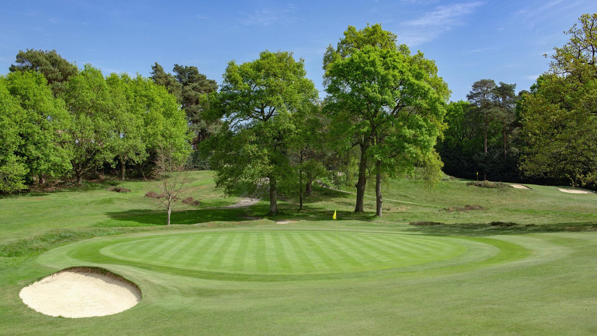 A sand bunker sits to the left of the green