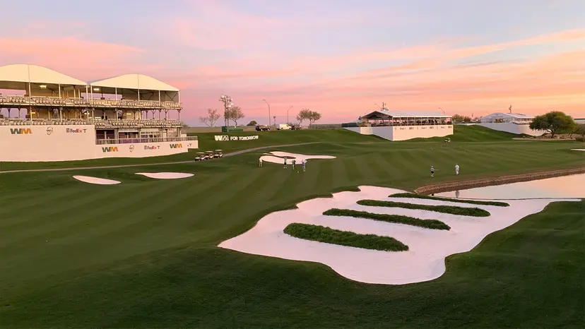 Sunset view of a green with grandstands set up for a PGA Tour event.