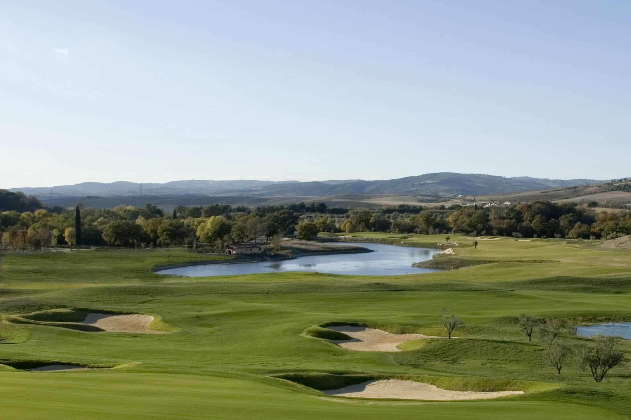 A winding fairway running along a water hazard leading to a smooth green surrounded by sand bunkers