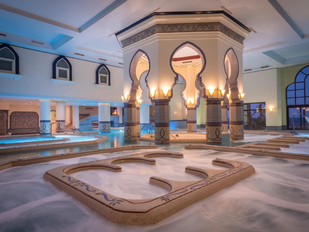 Indoor swimming pool at the hotel with grand pillars surrounding the central jacuzzi