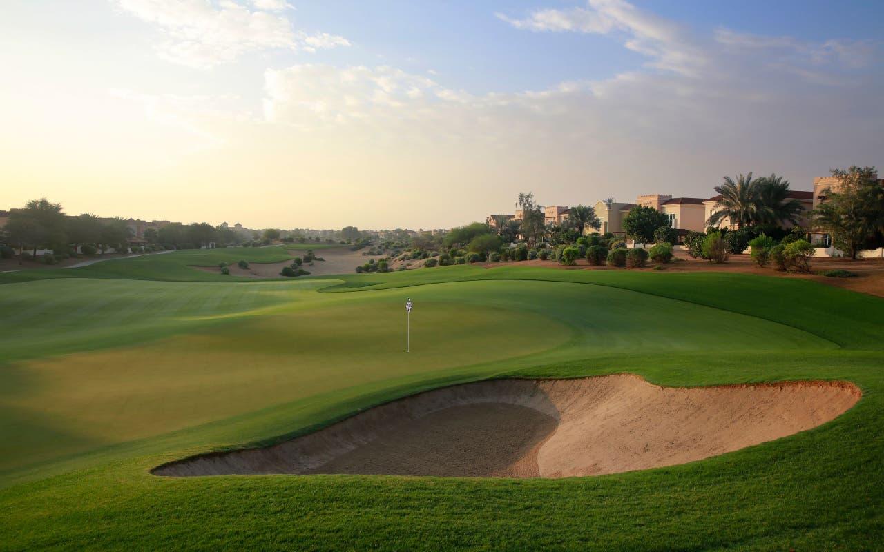 A wide fairway leading to a smooth green surrounded by a sand bunker