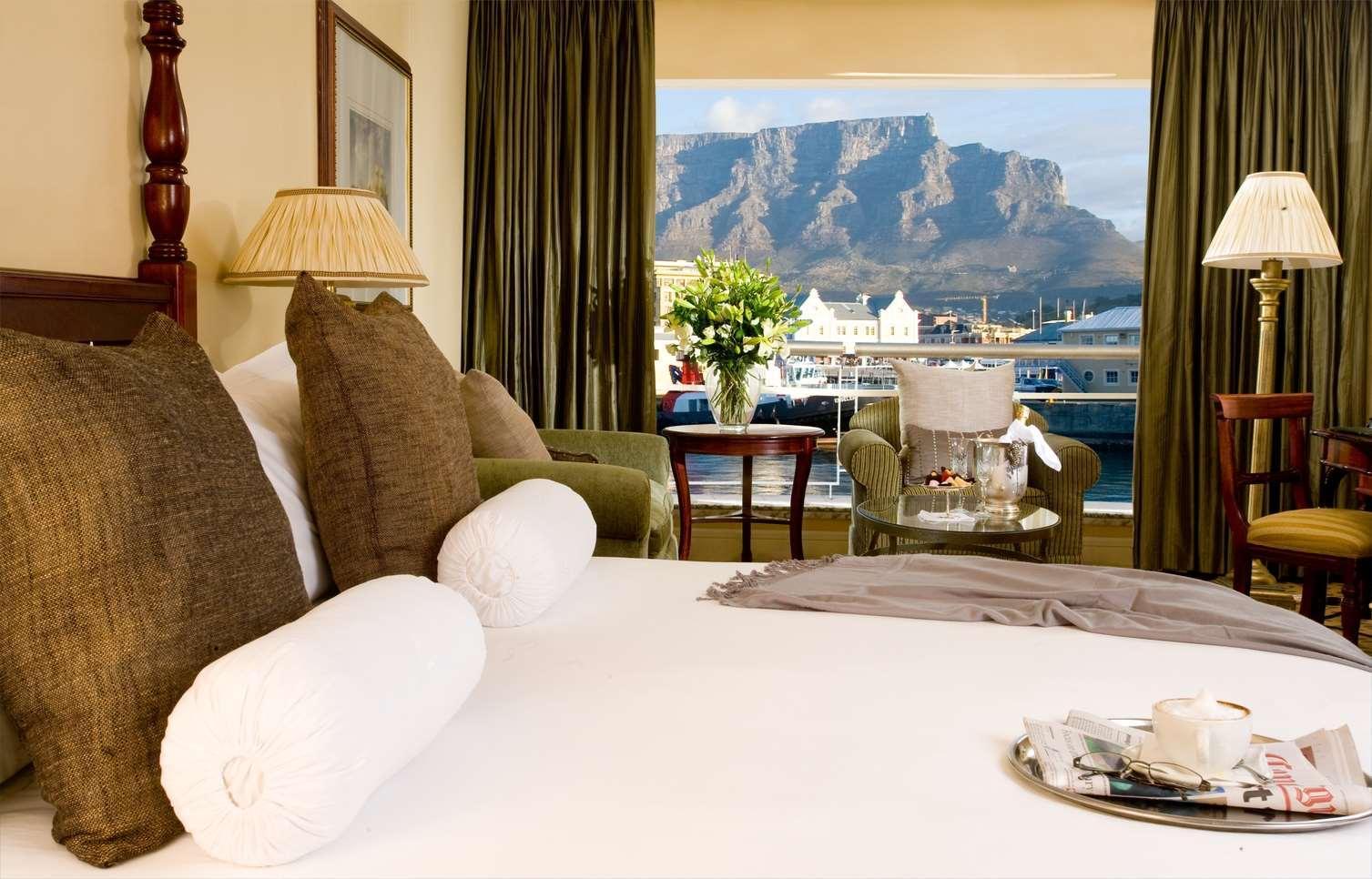 Double bed room at the The Table Bay Hotel with balcony views of a dockyard