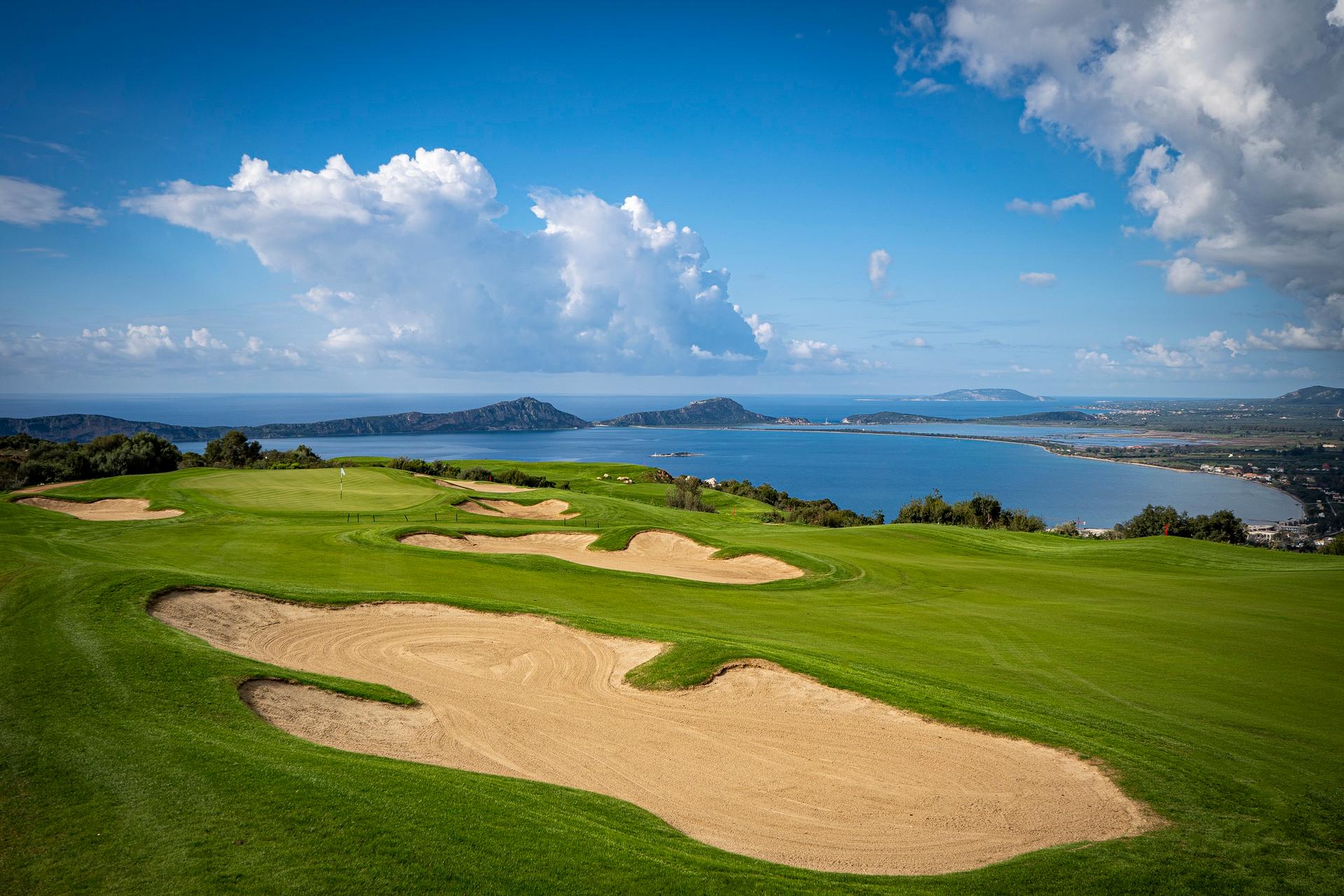 Stunning golf course views overlooking the sea and distant islands under a bright sky.