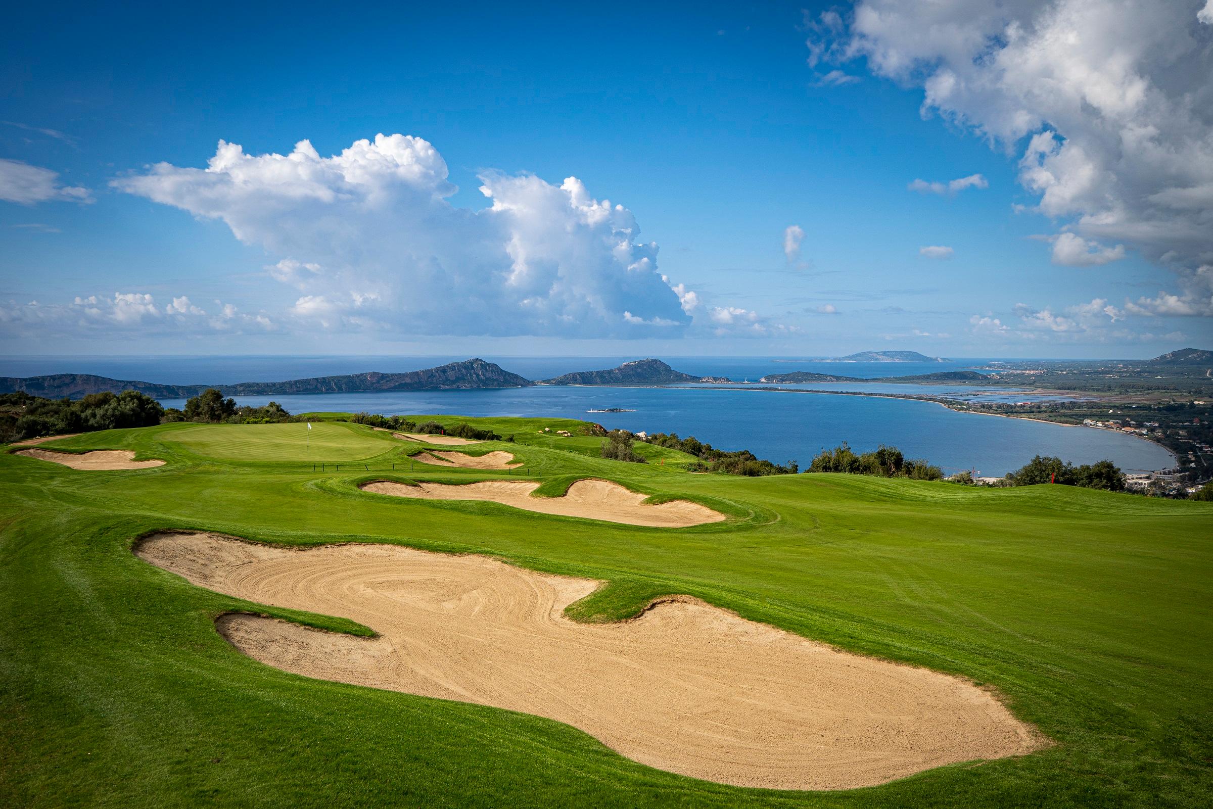 Stunning golf course views overlooking the sea and distant islands under a bright sky.