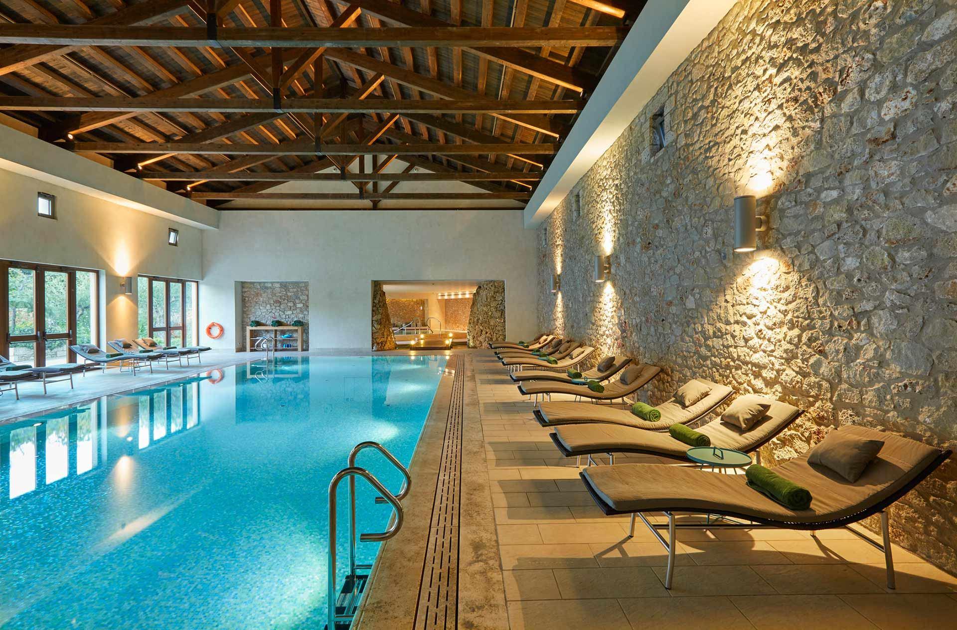 Indoor swimming pool at the resort with the wall lights reflecting off the water