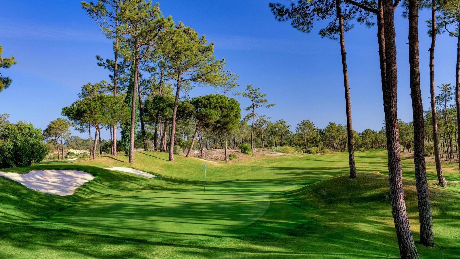 Narrow, undulating fairway leading to a green at Troia Golf
