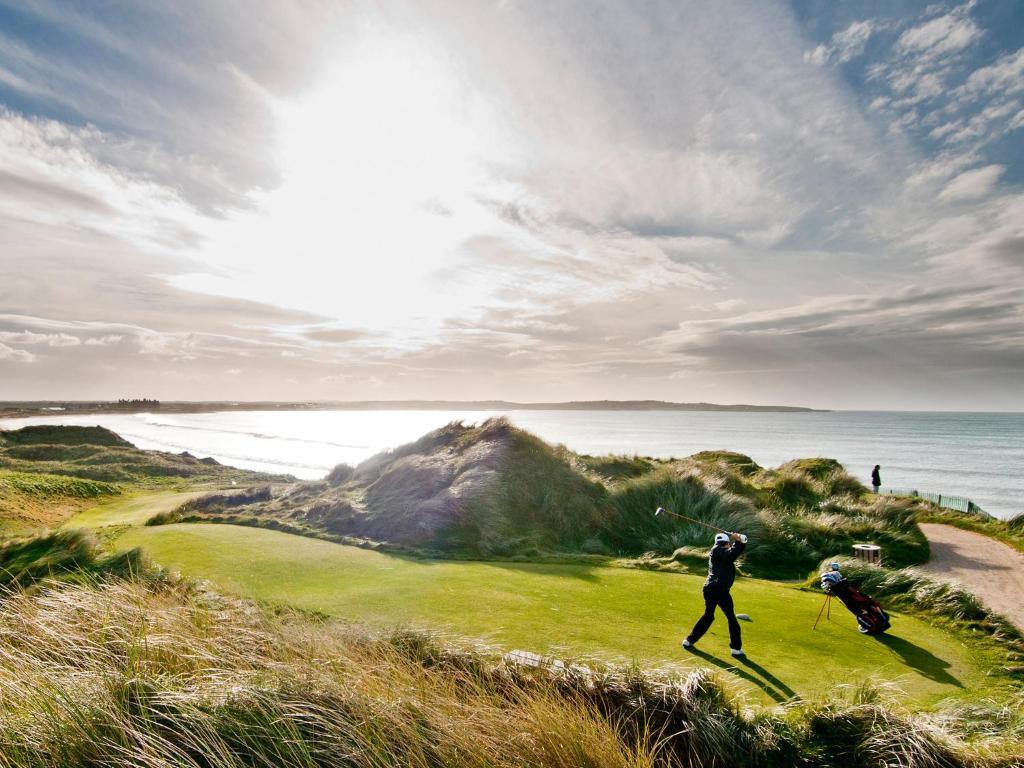 A golfer tees off overlooking the ocean at Trump Doonbeg.