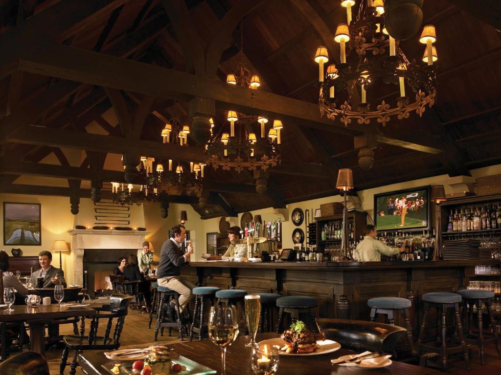 A warm, inviting bar with rich wooden interiors and cozy lighting.