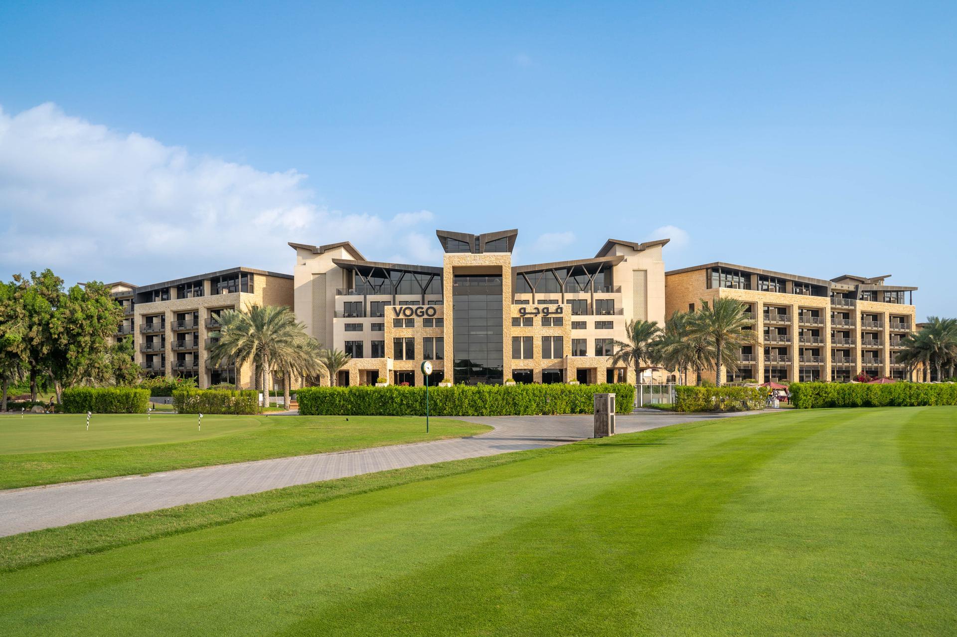 The VOGO Abu Dhabi Golf Resort & Spa building under blue skies