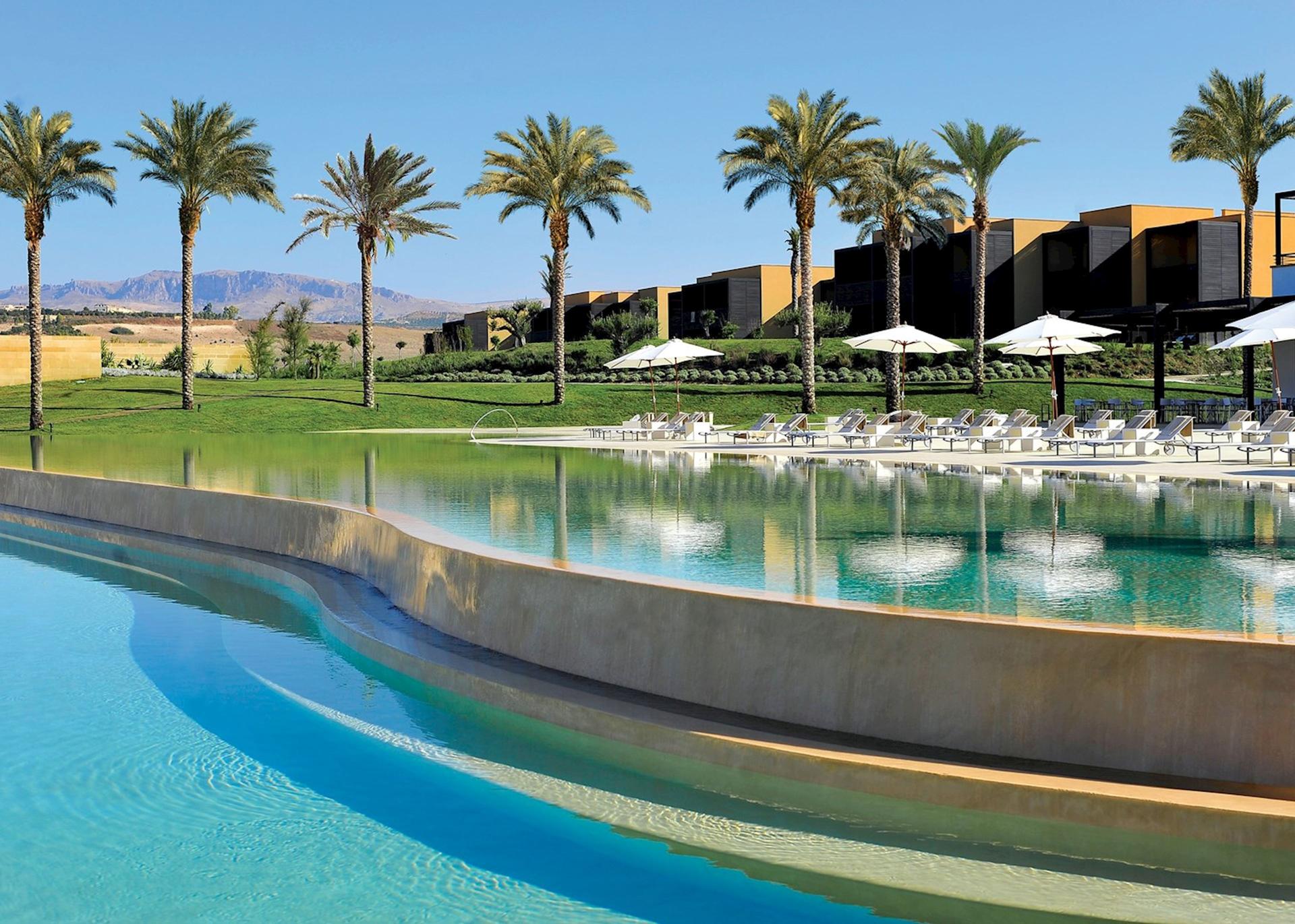 Swimming pool surrounded by sunbeds at the Verdura Golf & Spa Resort