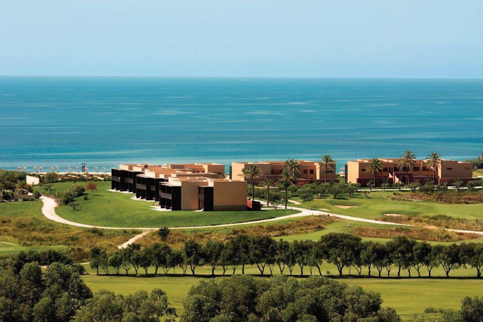 The Verdura Golf & Spa Resort with coastal views and a bordering tree lone
