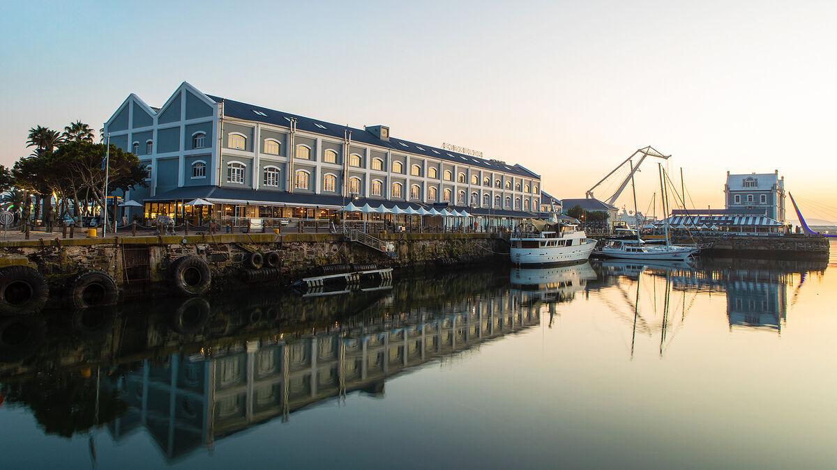 Exterior view of the sea reflecting the hotel building at sun set