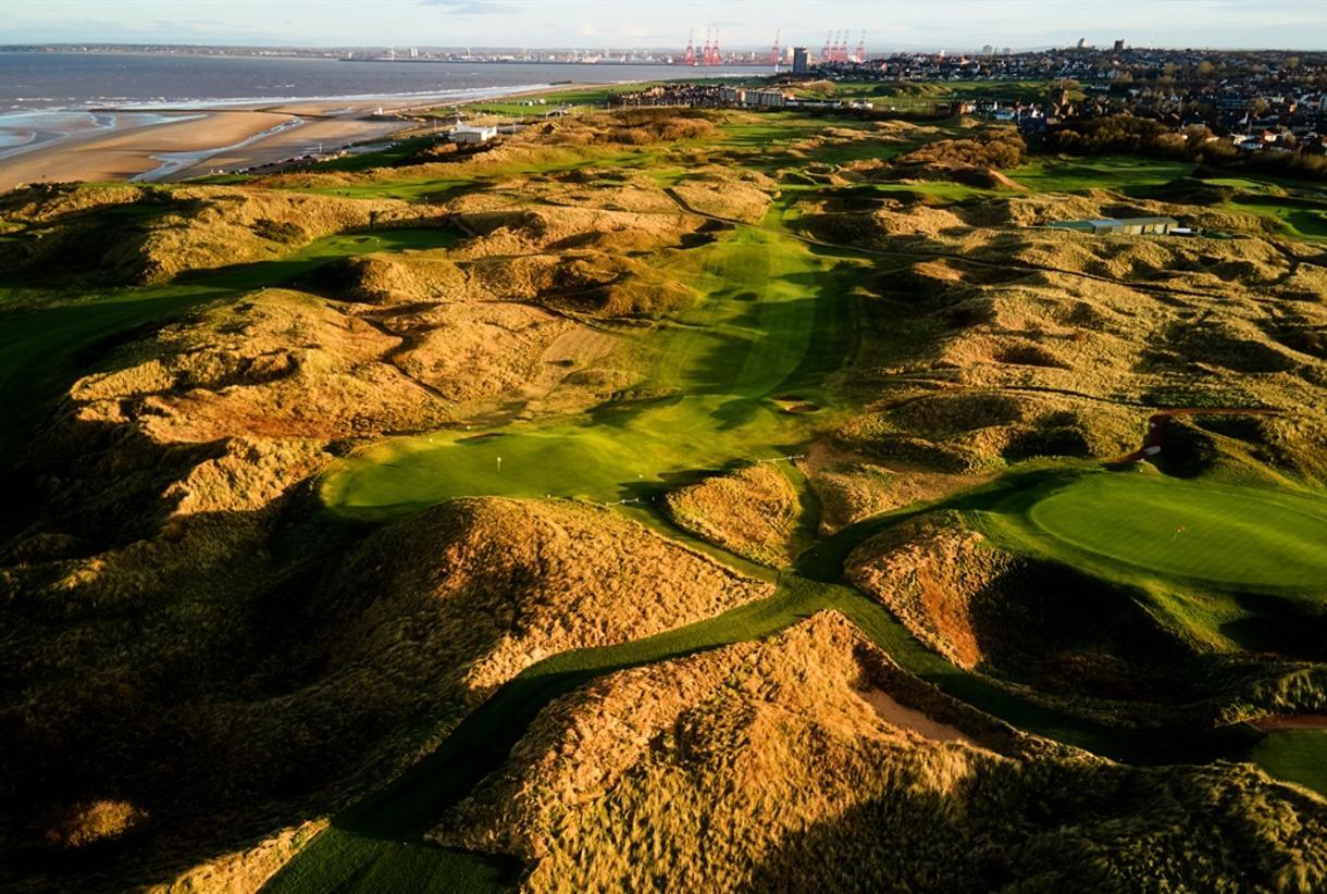 An aerial shot showcasing the intricate dune layout of a dramatic links golf course.