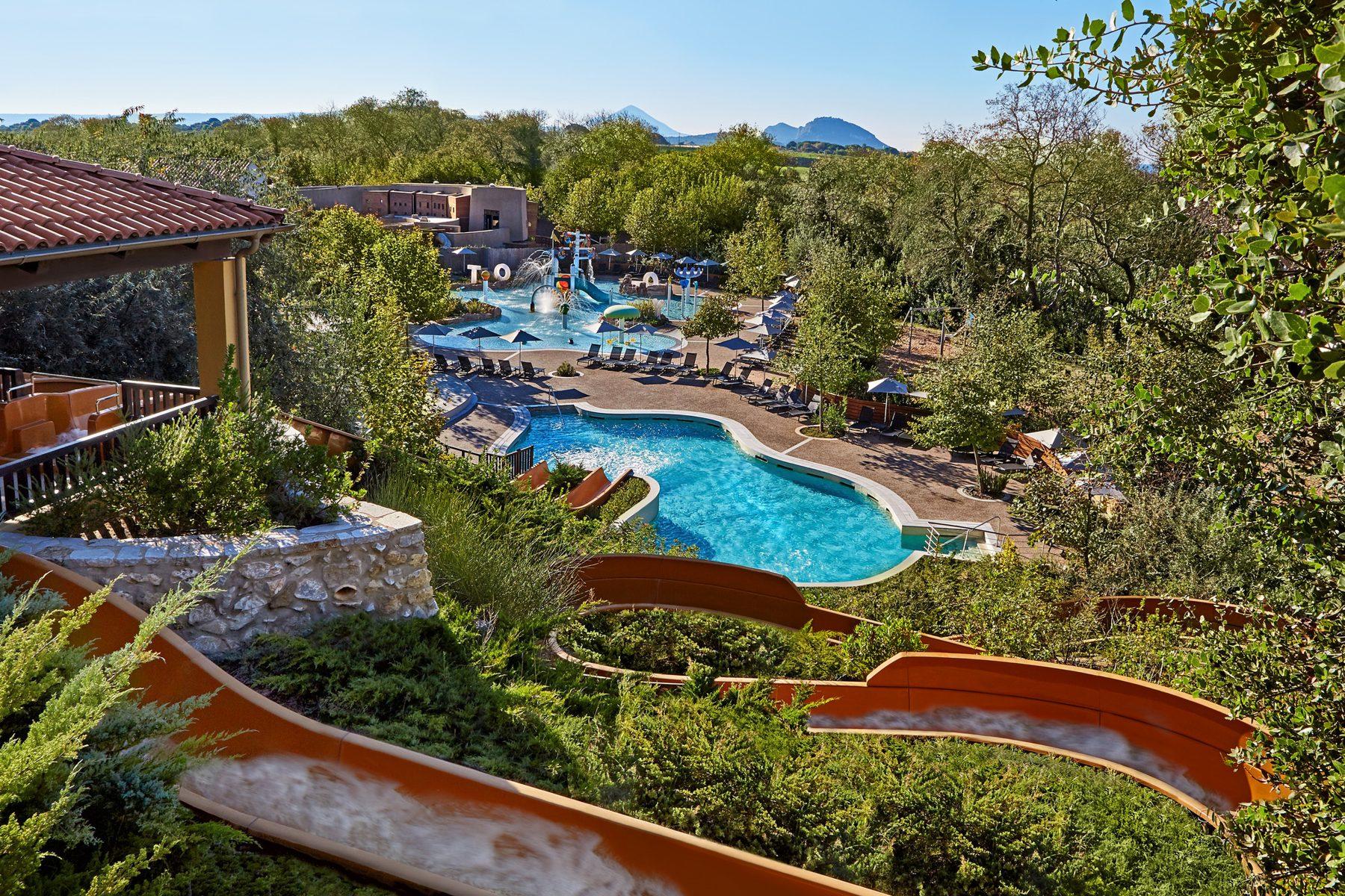 Overhead view of a winding orange water slide leading to the kids swimming pool