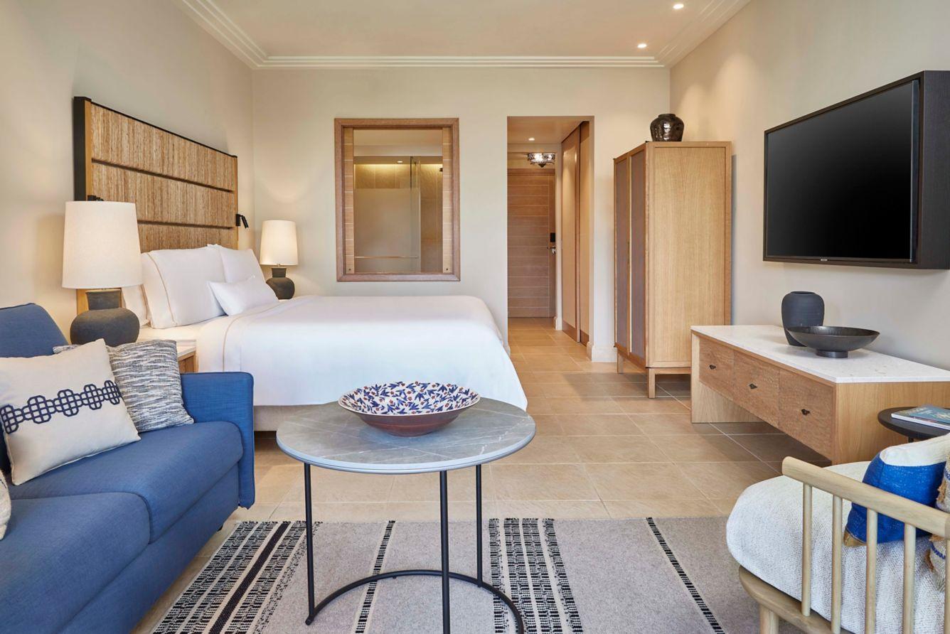 Double bed room following a wooden design flat screen TV and window to the bathroom