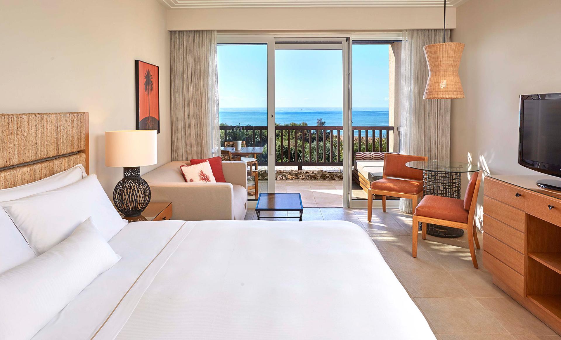 Double bed room at the hotel featuring a balcony with coastal views