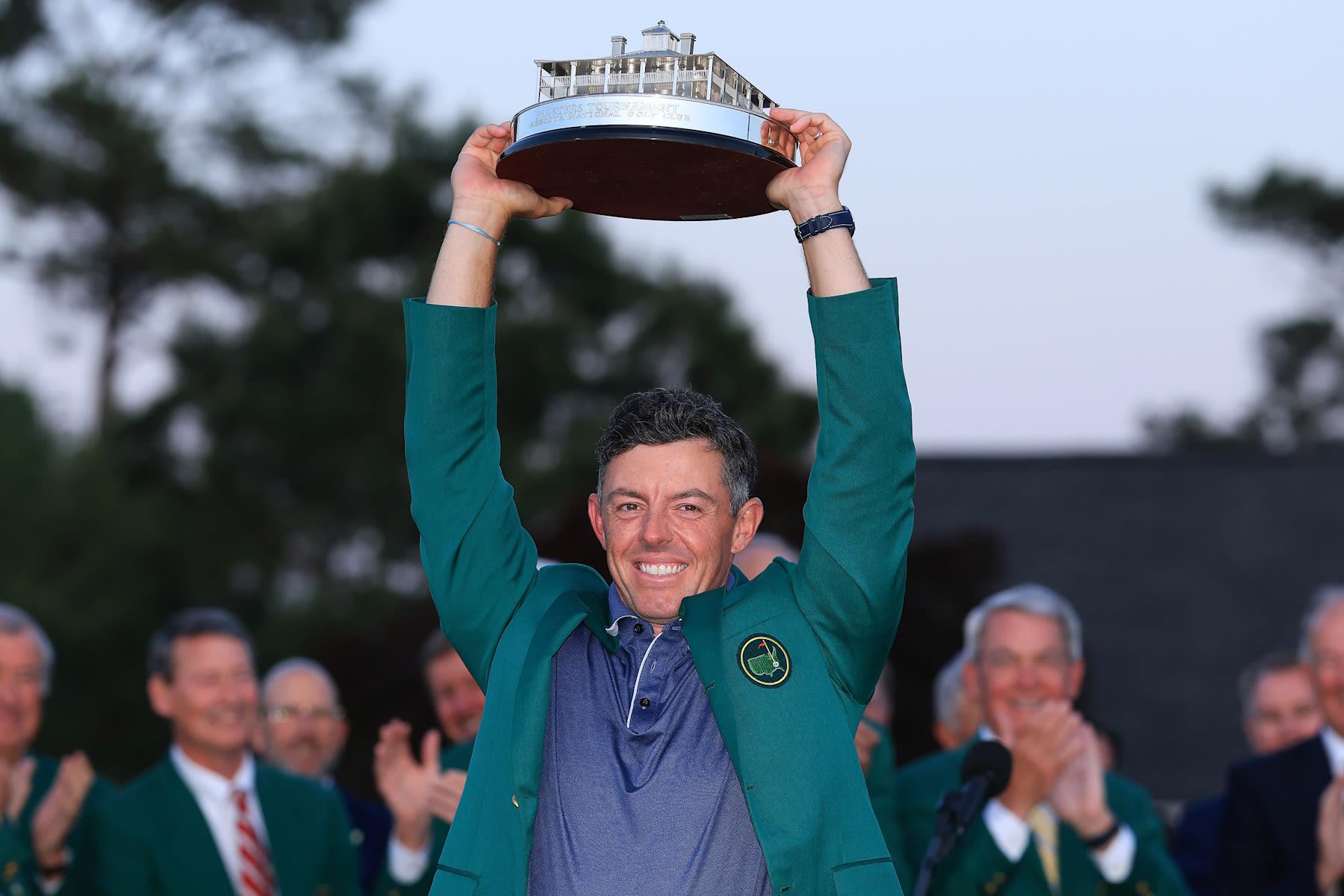 Rory McIlroy lefting the trophy and wearing his Green Jacket after the 2025 Masters