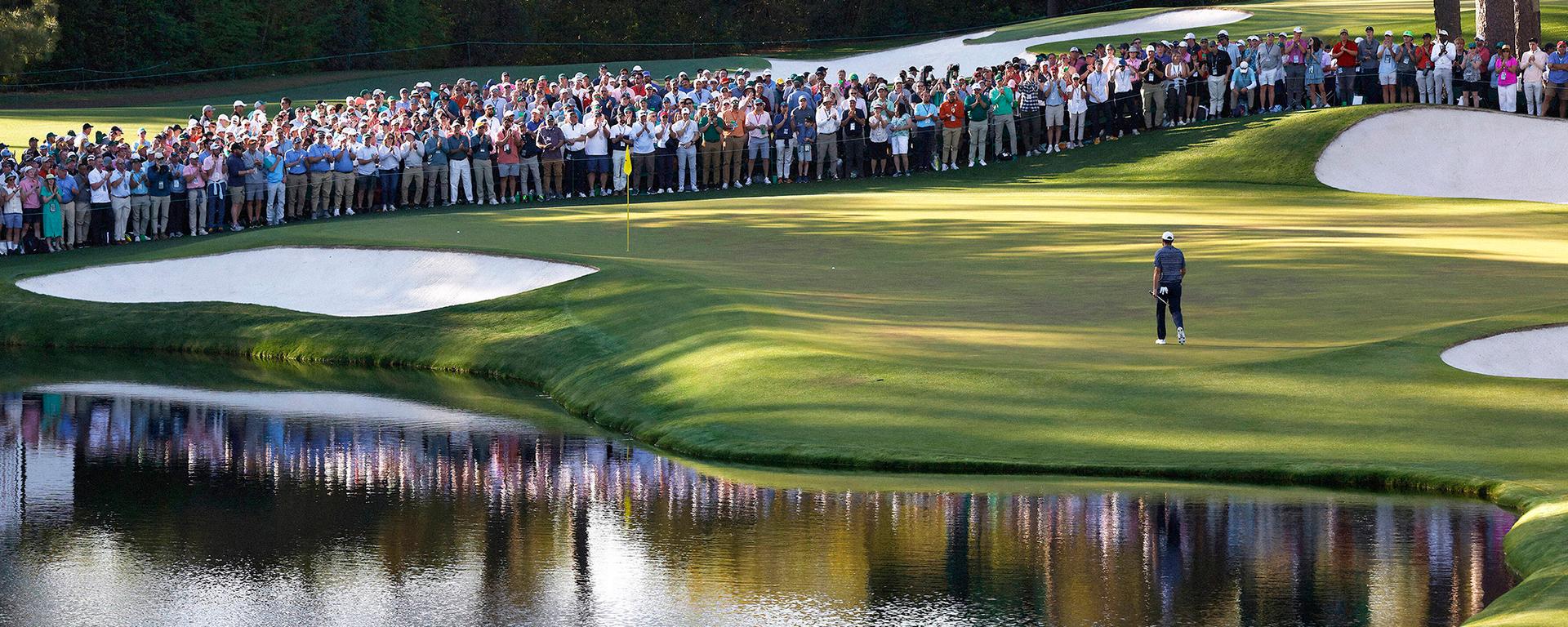 Player approaching the hole at The Masters with crowds in the background