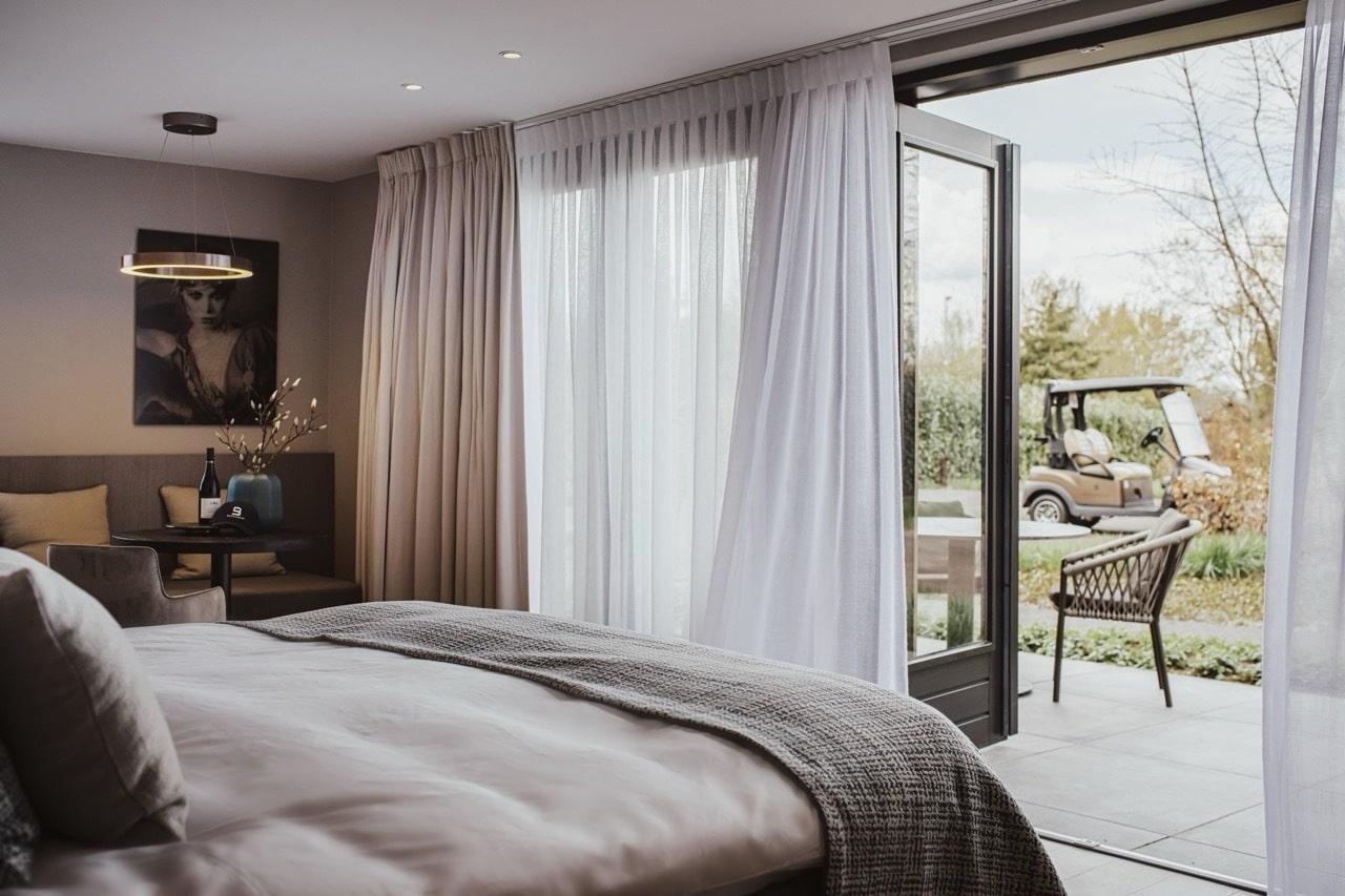 A modern double bed room with a patio space and a buggy parked outside