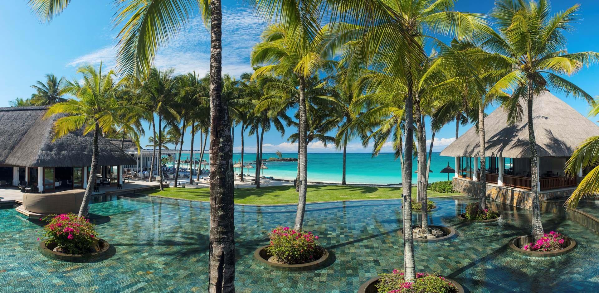 Outdoor pool area at Constance Belle Mare Plage with the Indian Ocean in the background
