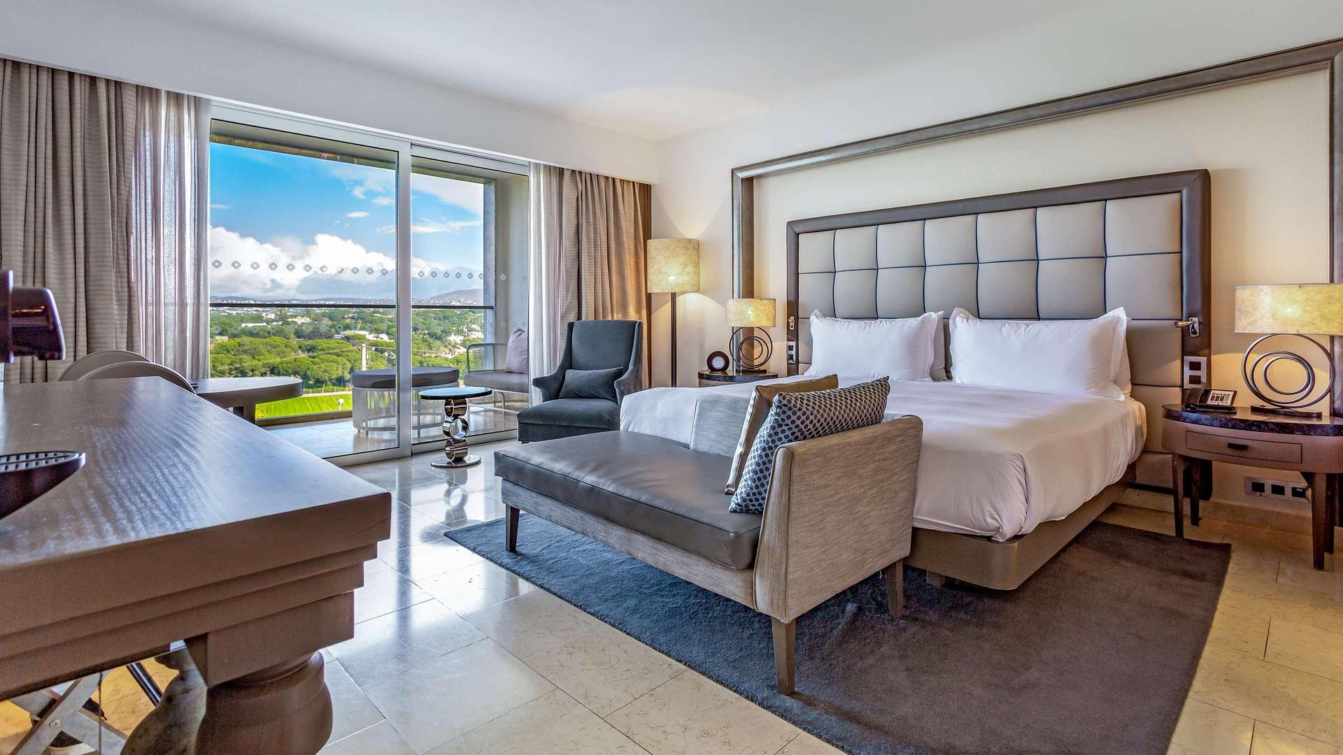 A spacious double bed suite with balcony views of the surrounding landscape