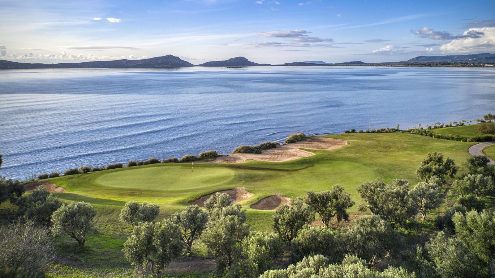 Overhead view of a well maintained green with sea views