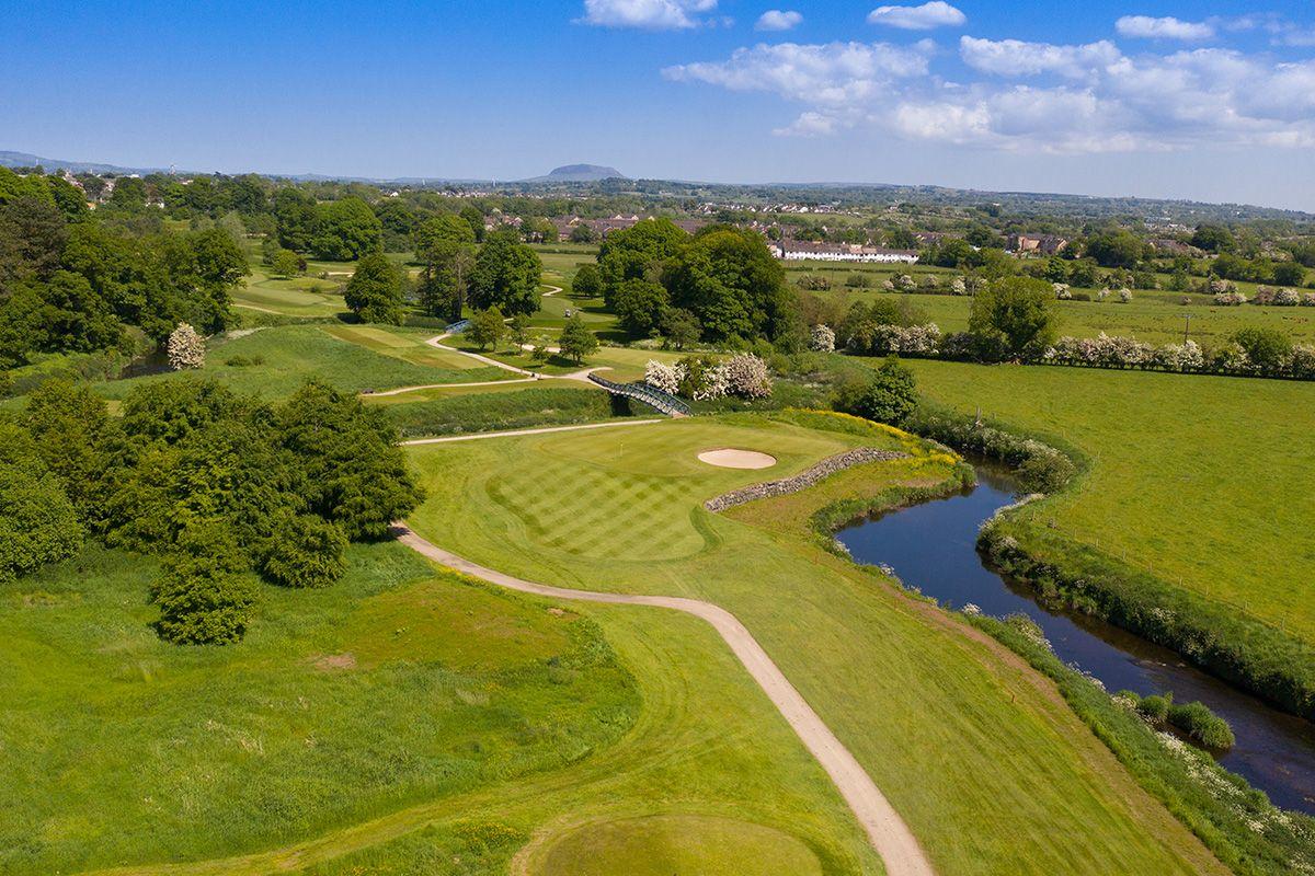 Overhead view of a lake water hazard flowing next to a fairway