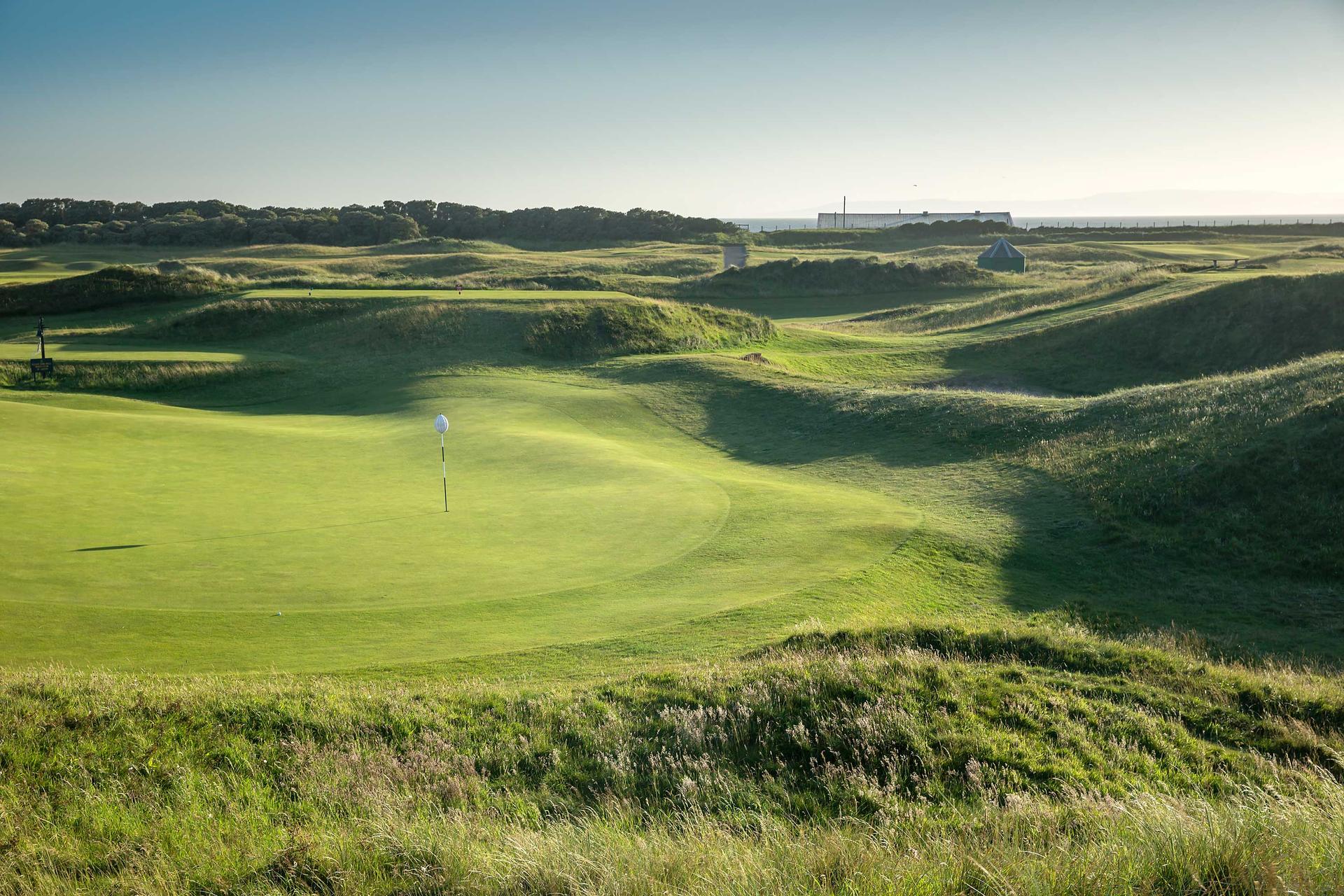 Classic links course at Prestwick Golf Club. Narrow, undulating fairway leading to a sloping green surrounded by thick rough
