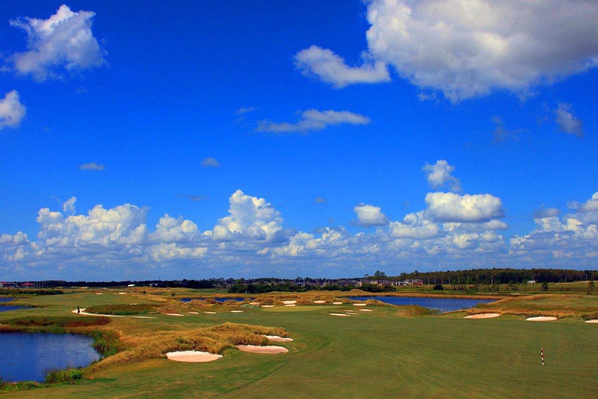 A well maintained fairway nestled with sand bunkers