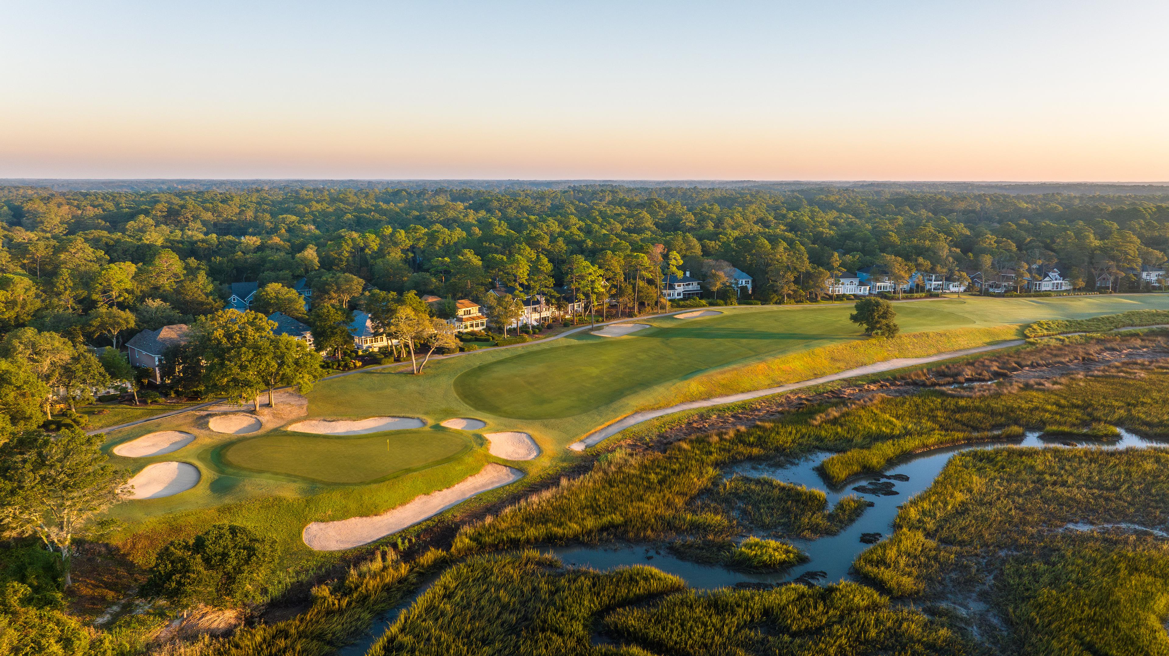 Narrow fairway with trees on one side and water on the other