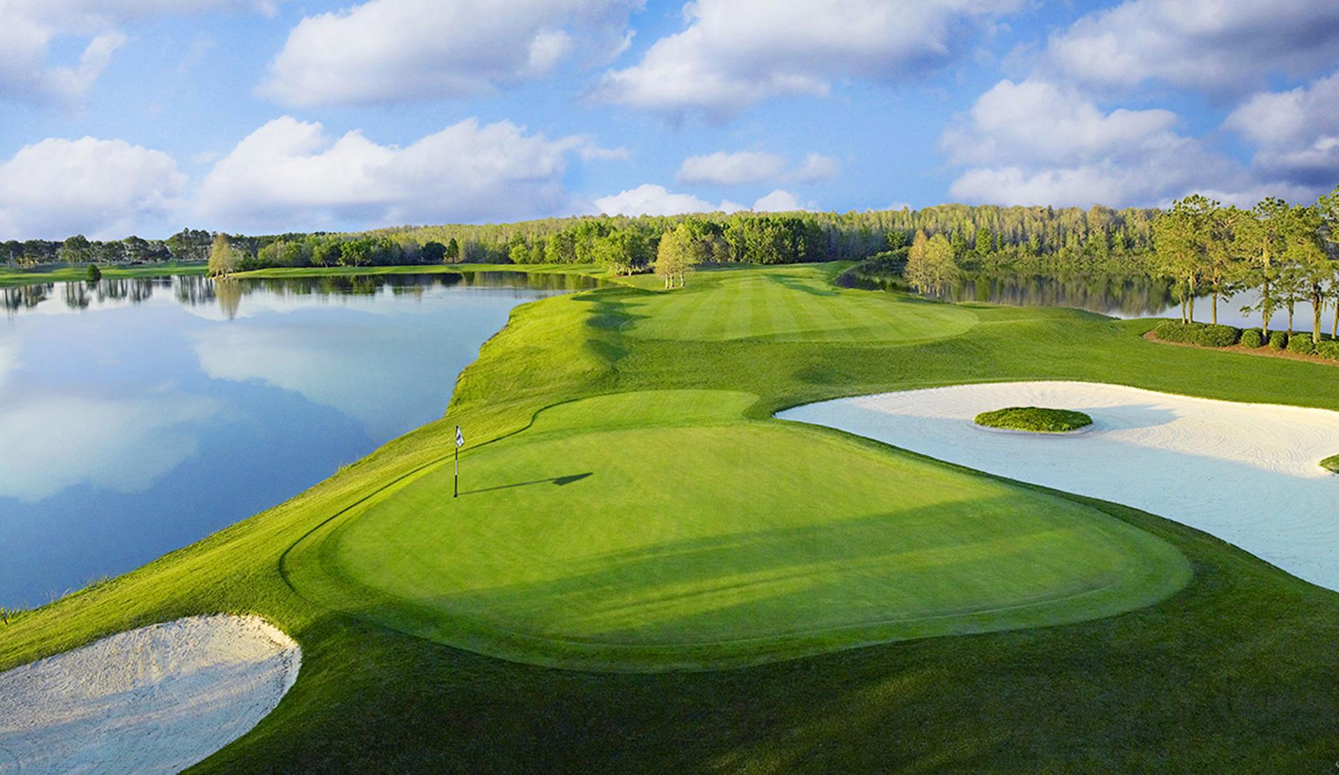 Manicured green with two bunkers around it and a large water hazard at the side