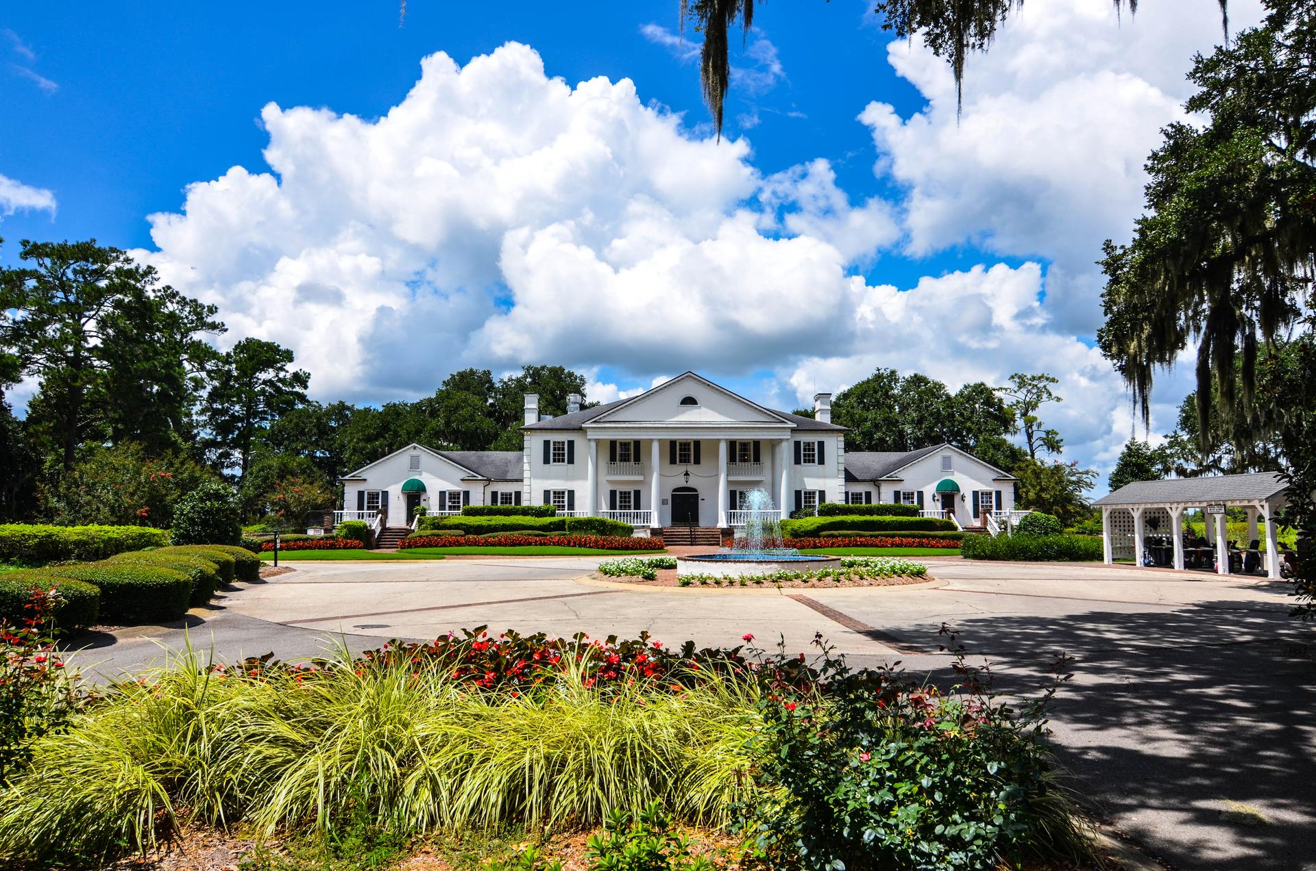 The Pawleys Plantation Resort building with a water fountain in the drive