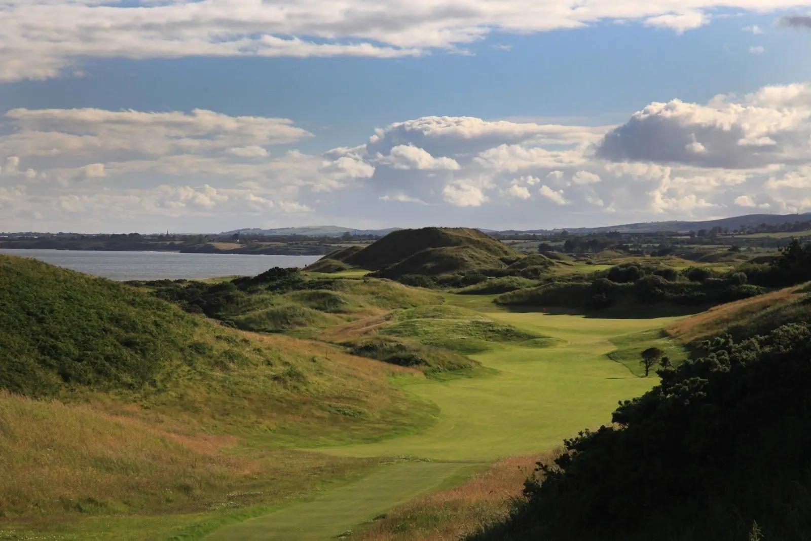 Aerial view of a winding fairway surrounding by a hilly rough