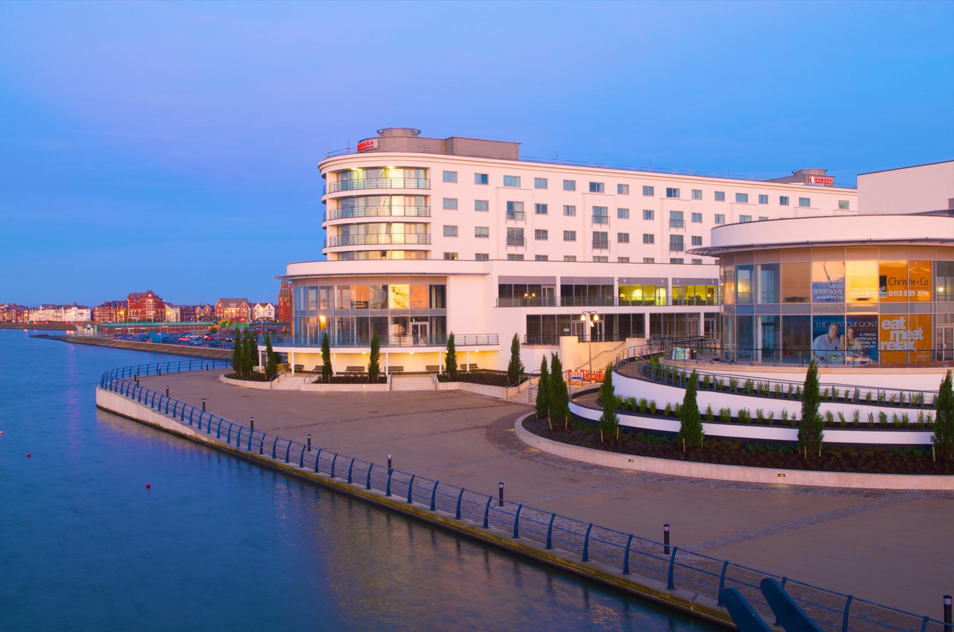 Panoramic view of The Waterfront Southport Hotel with the sunset reflecting off the window
